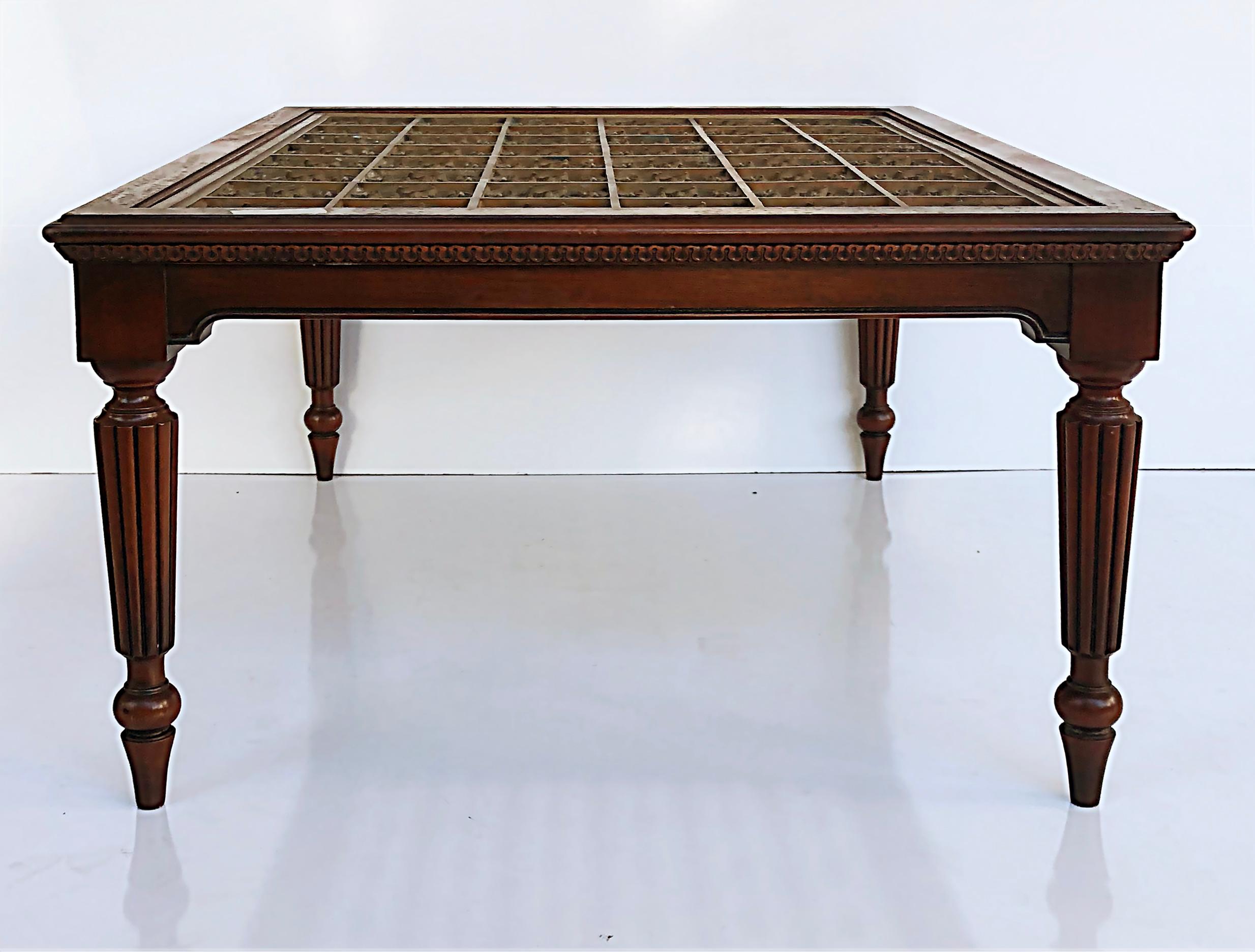 British Colonial Style coffee table with inset bronze. Christie's auction label.

Offered for sale is a British Colonial-style coffee table with an inset bronze grate. The tabletop is supported by four turned tapering legs with fluting. This table