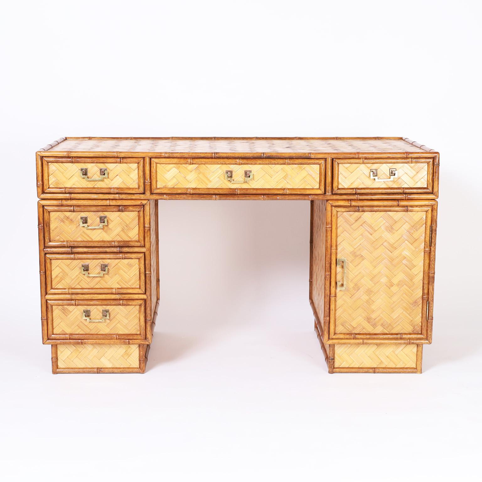 In vogue Asian modern desk with six drawers and a cabinet, faux bamboo frame, herringbone woven reed panels all around, Asian modern brass hardware and block feet.