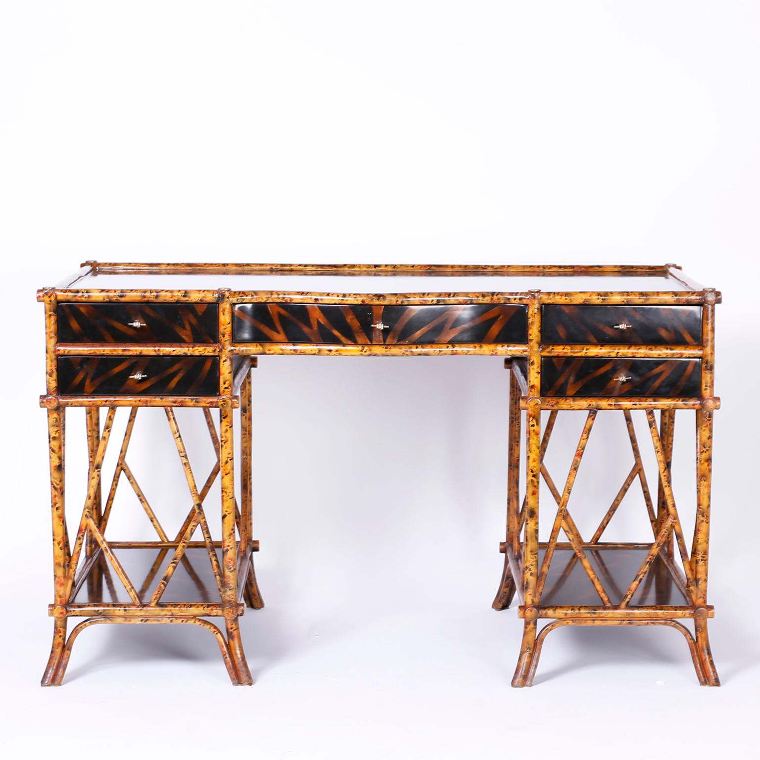 Five-drawer desk with a faux bamboo frame with a faux tortoise finish and featuring faux jungle lacquered panels, brass fist hardware, criss cross supports and splayed feet. Signed Maitland -Smith in a drawer.