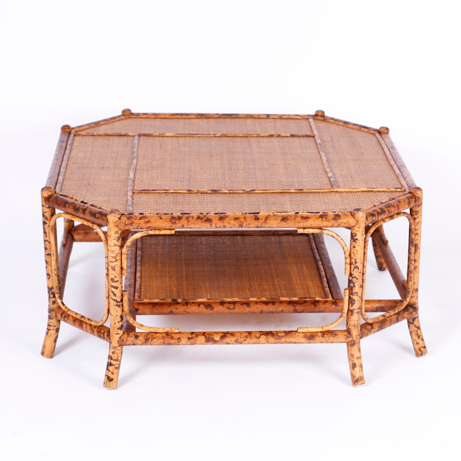 British Colonial octagon form coffee table with an eight legged faux burnt bamboo frame having splayed feet and two tiers of grasscloth horizontal surfaces. Perfect mix of Classic and modern.