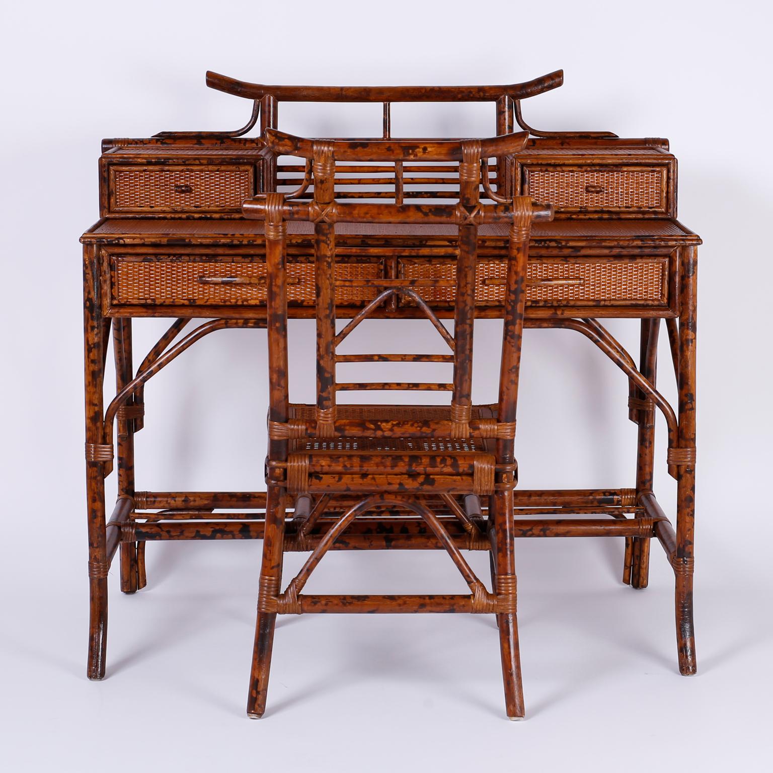 Midcentury faux tortoise and grass cloth desk with a hip Asian modern form featuring a pagoda gallery over two glove boxes, a case with two drawers, elegant legs with support brackets and a matching caned seat chair.

Measures: Desk: H 40, W 41.5,