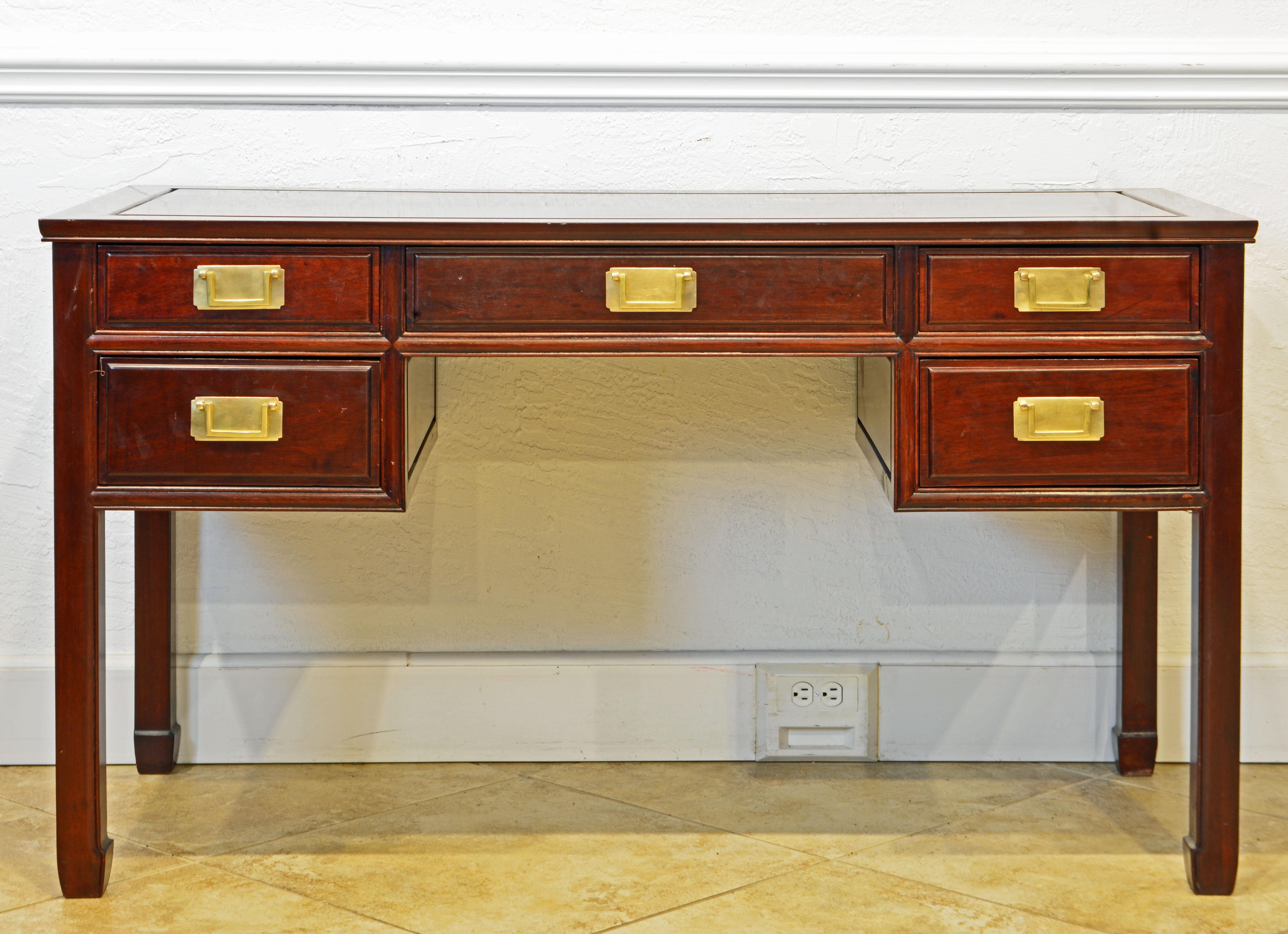This British Colonial style writing desk is made with great craftsmanship of solid polished mahogany, even the five drawers. It is likely to originate in Hong Kong dating to circa 1970. All surfaces are made as framed panels, even the top, which