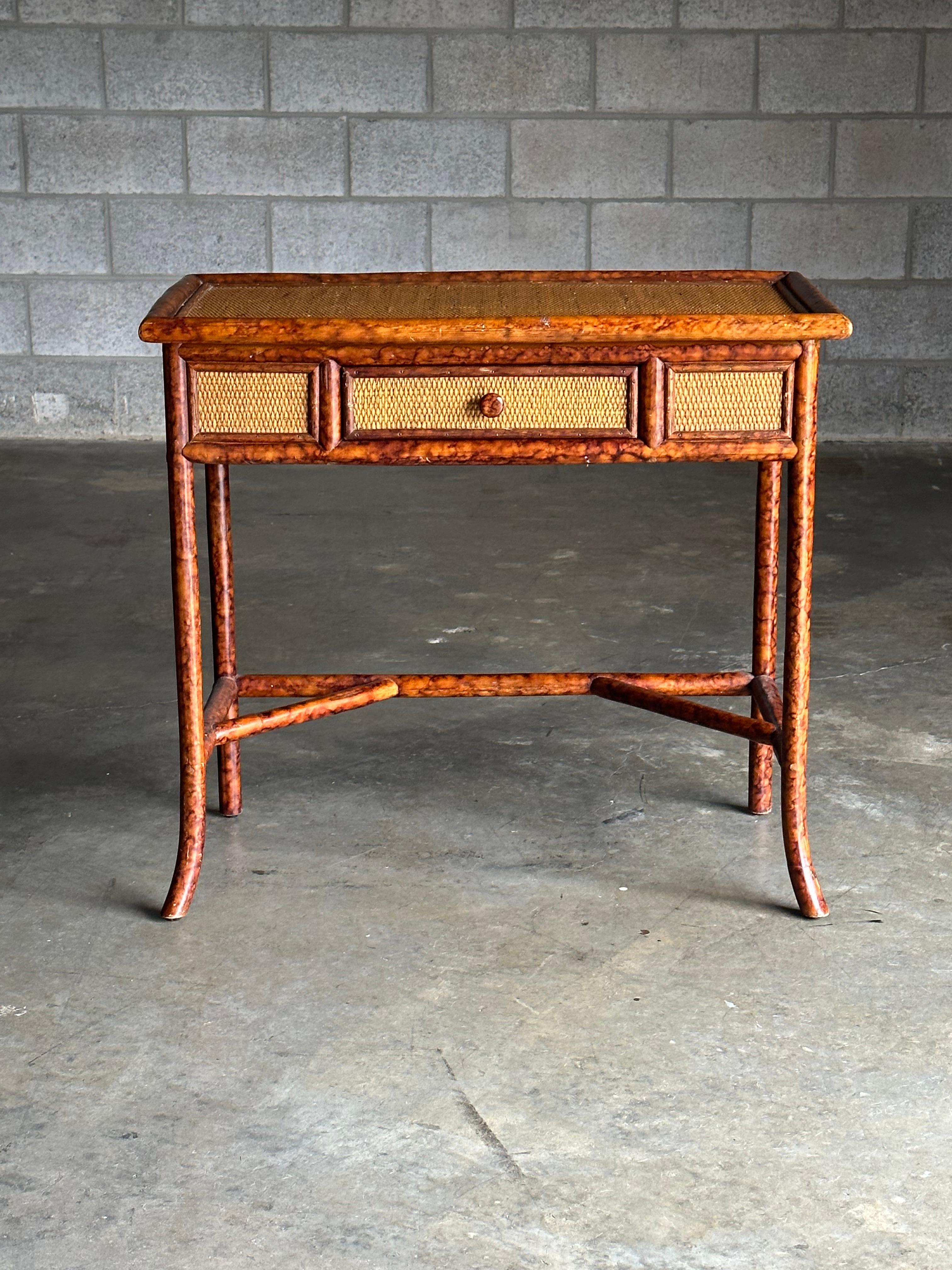 Gorgeous petite desk, console table, or vanity. Has many different uses. One small drawer in the middle. Framed in a faux burnt bamboo with cane sides, has a British Colonial style look.

Clearance under desk- 22.75