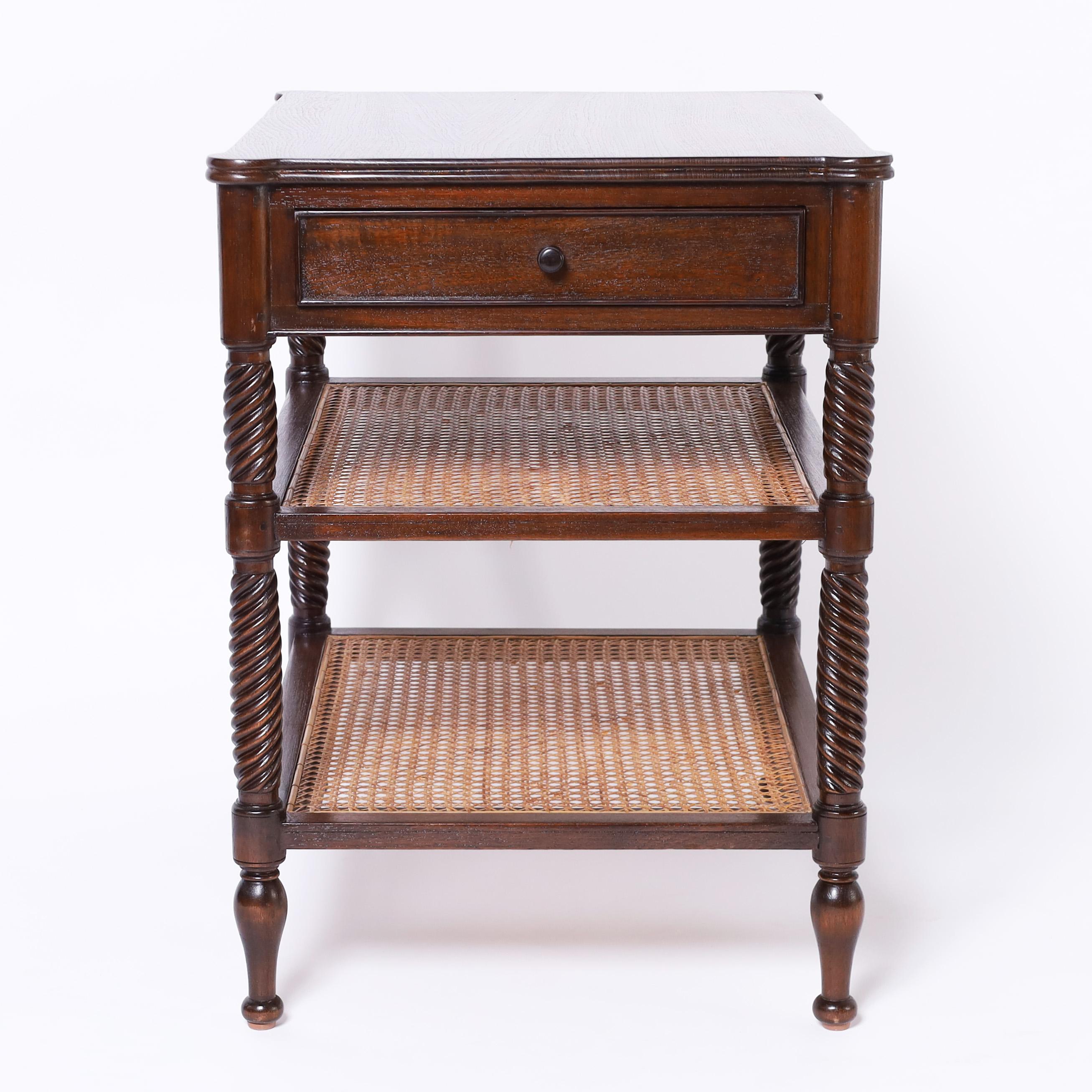 Standout English stand crafted in mahogany having one drawer over two caned lower tiers with turned and twisted supports over classic turned feet. 