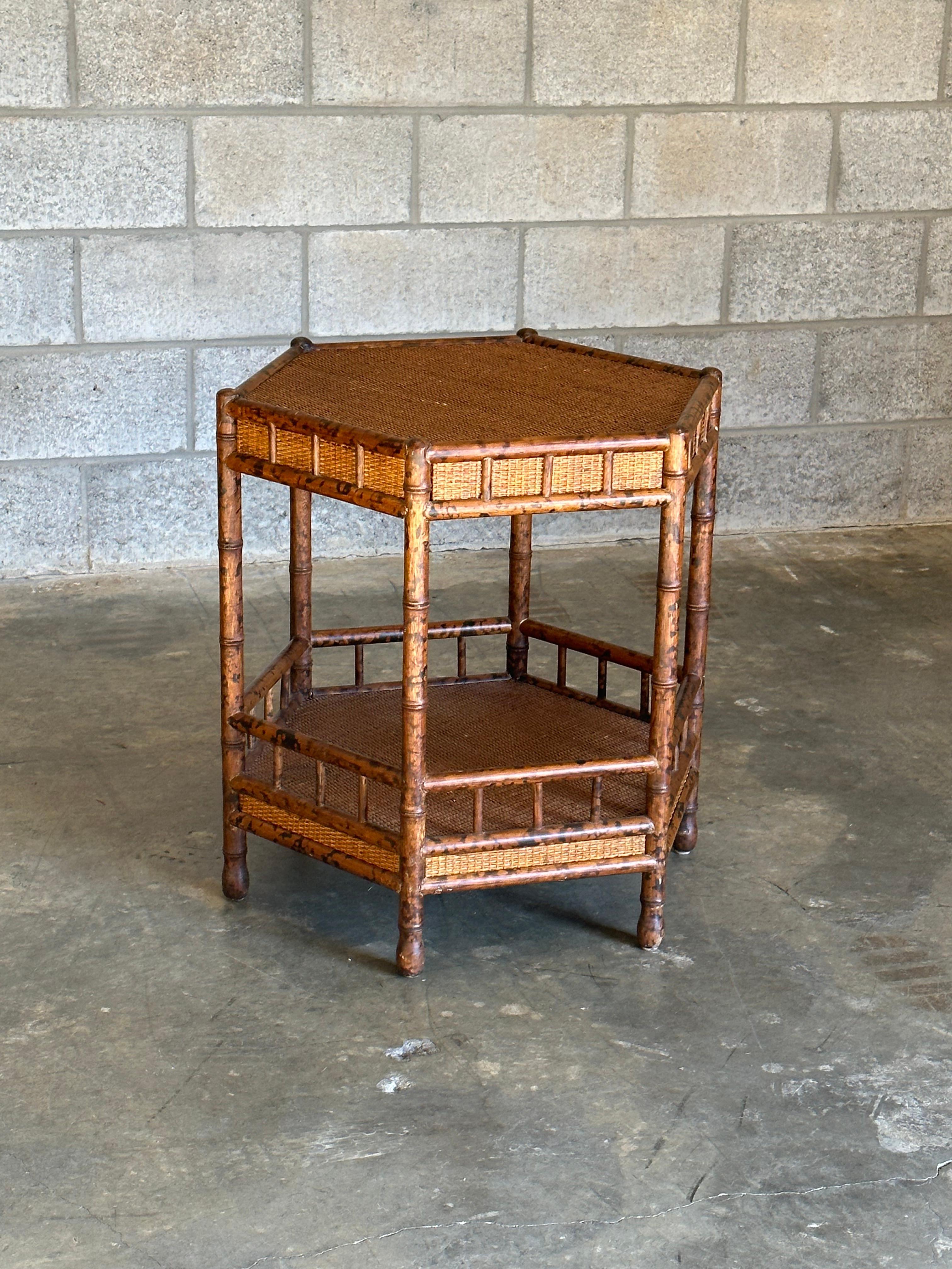 Oversized two tier table in faux bamboo and cane. Charming British Colonial style. This particular table was sold through Bloomingdales circa 1990s and is in wonderful condition. Attributed to designer Ralph Lauren.   

When measuring across from