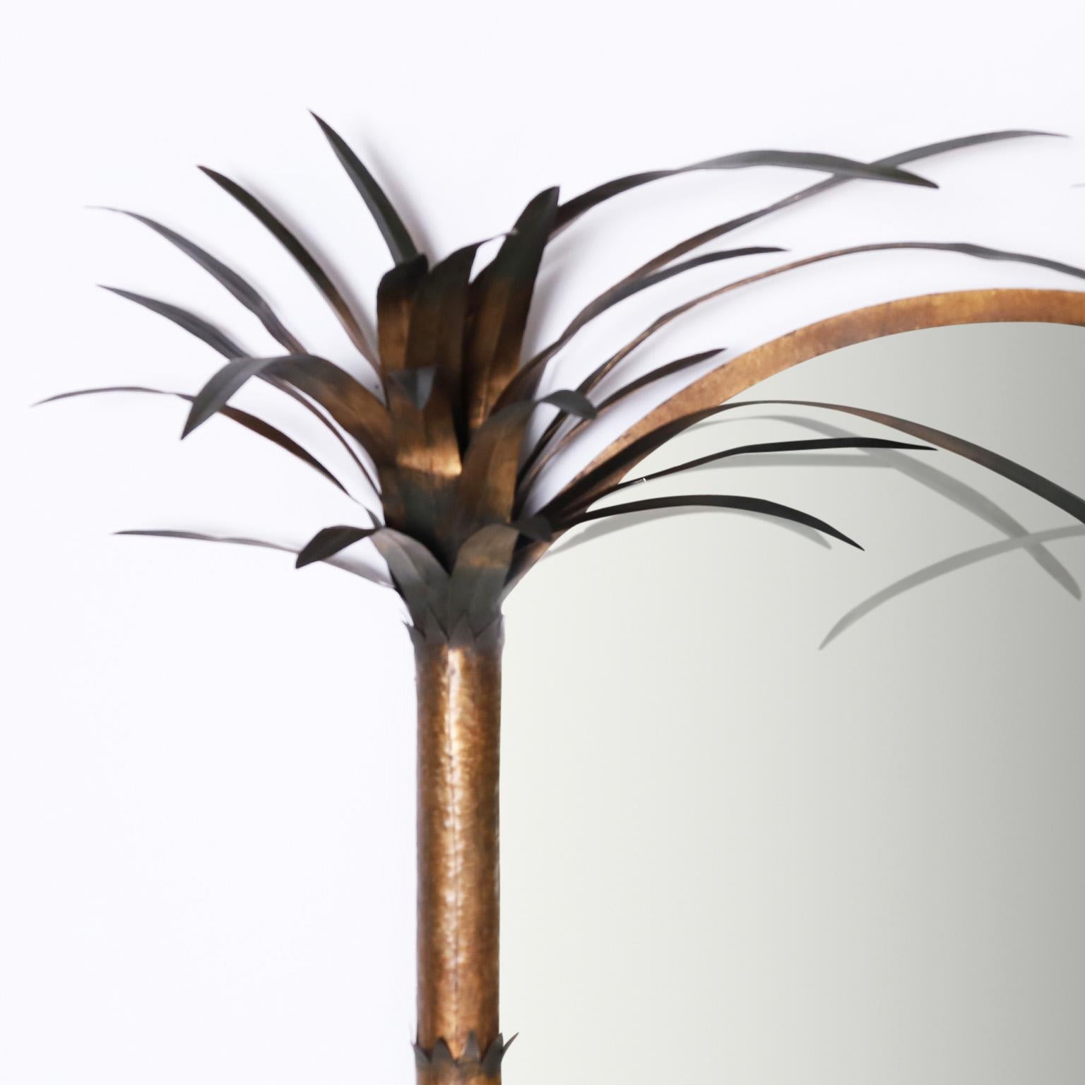 Italian tole or painted metal wall mirror with a dramatic composition having two palm trees joined by an arched top.