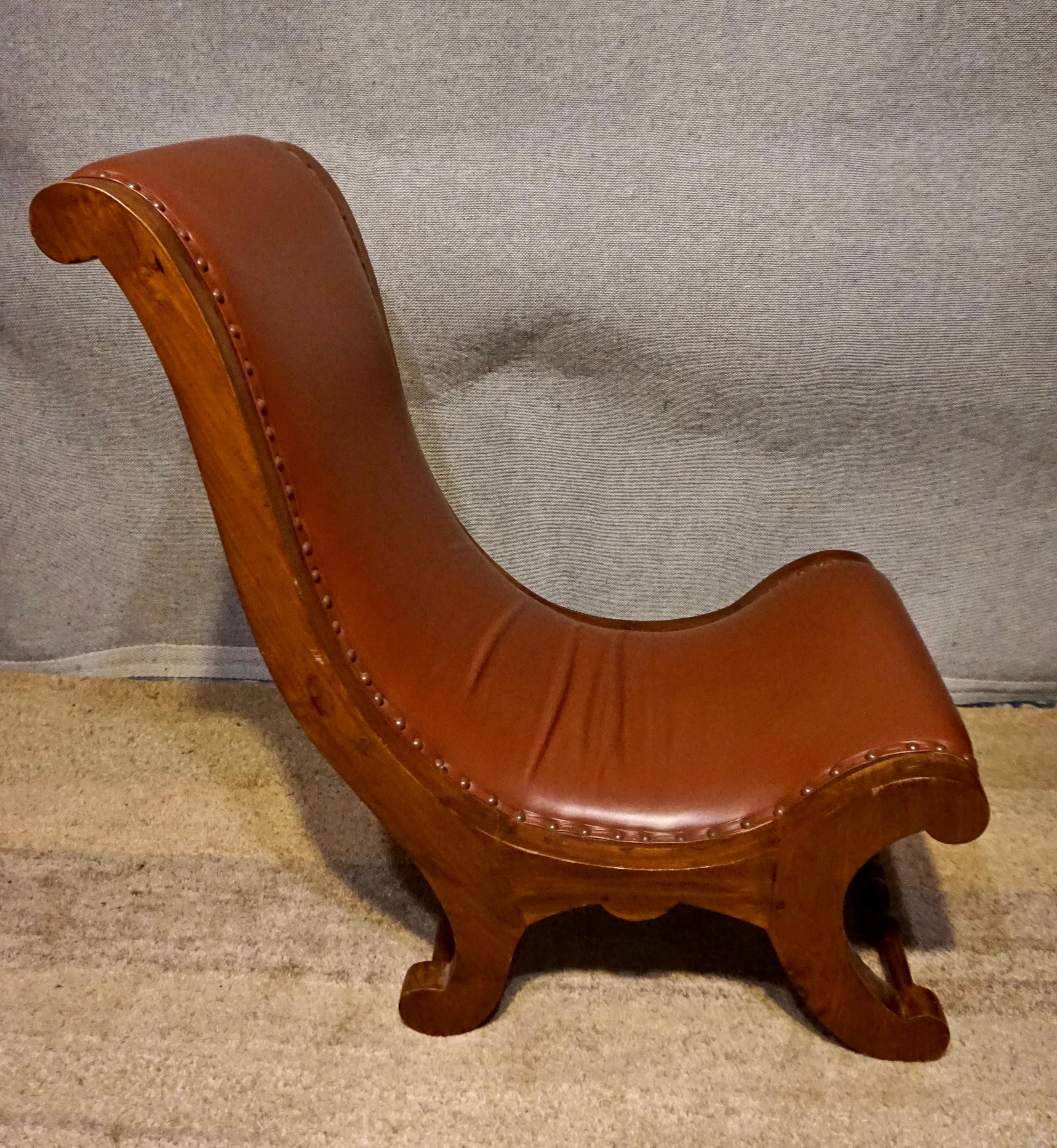 Circa 1920's

Hand carved Victorian Slipper chair constructed from Teak wood and re-upholstered in brown leather.