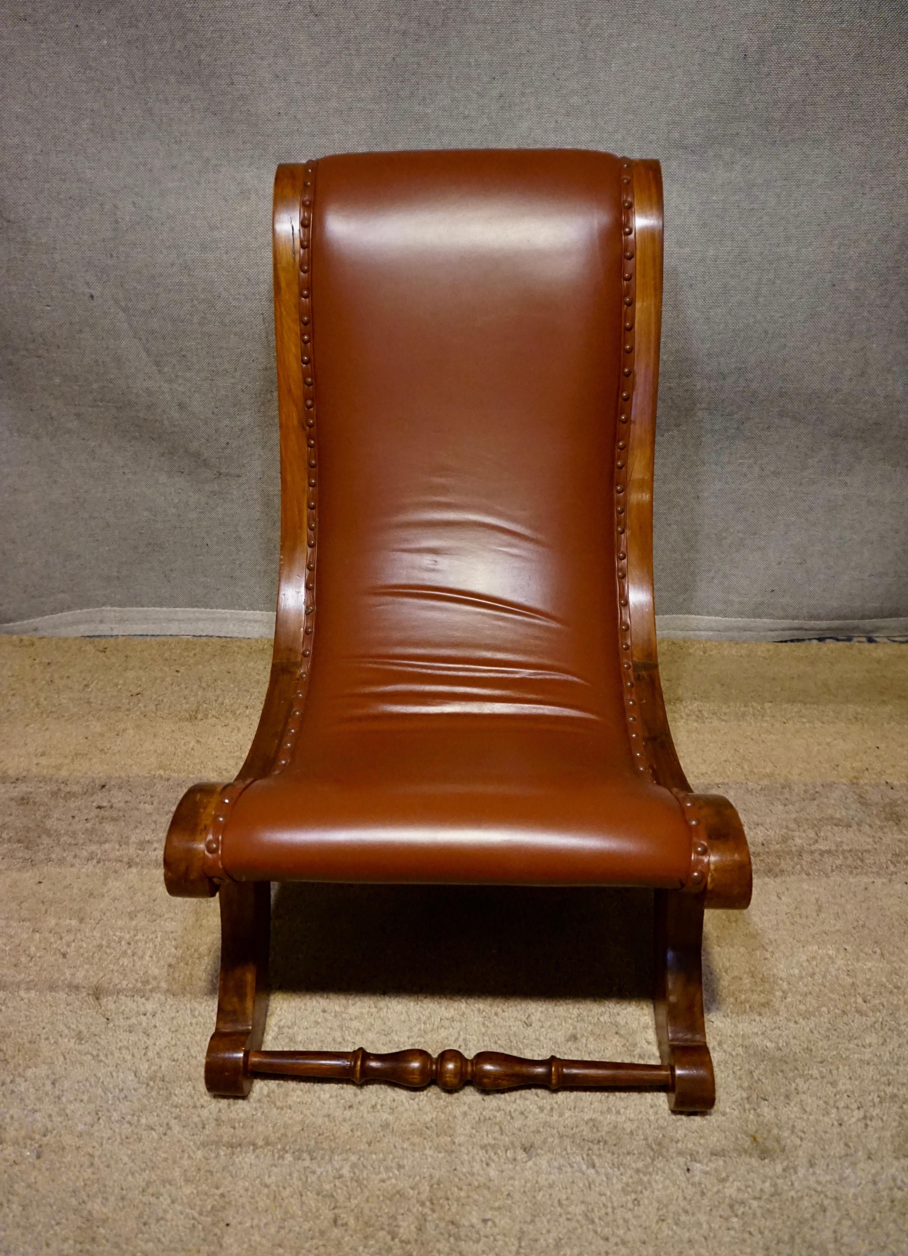 Carved British Colonial Teak Slipper Chair With Leather Upholstery For Sale