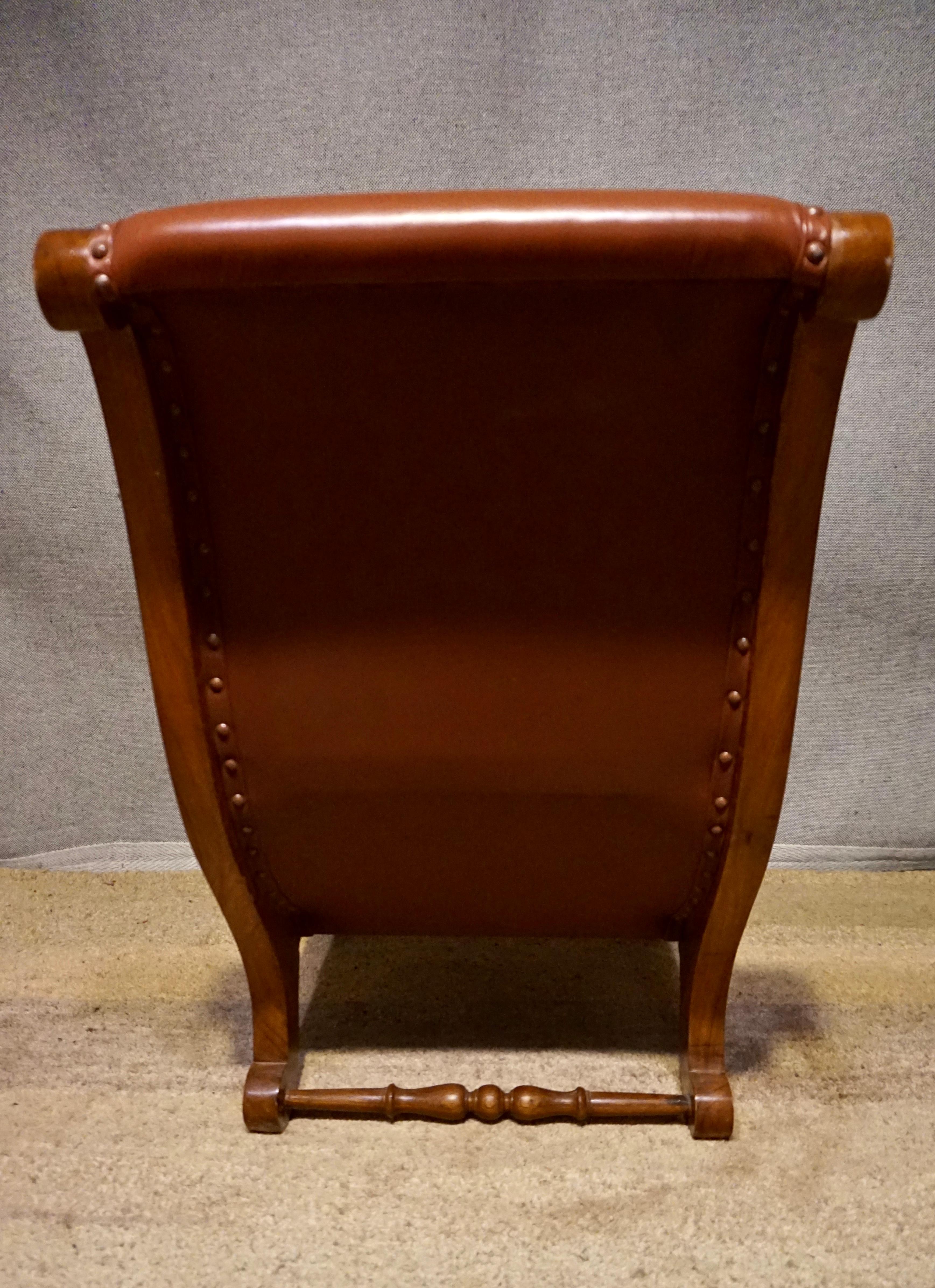 Early 20th Century British Colonial Teak Slipper Chair With Leather Upholstery For Sale