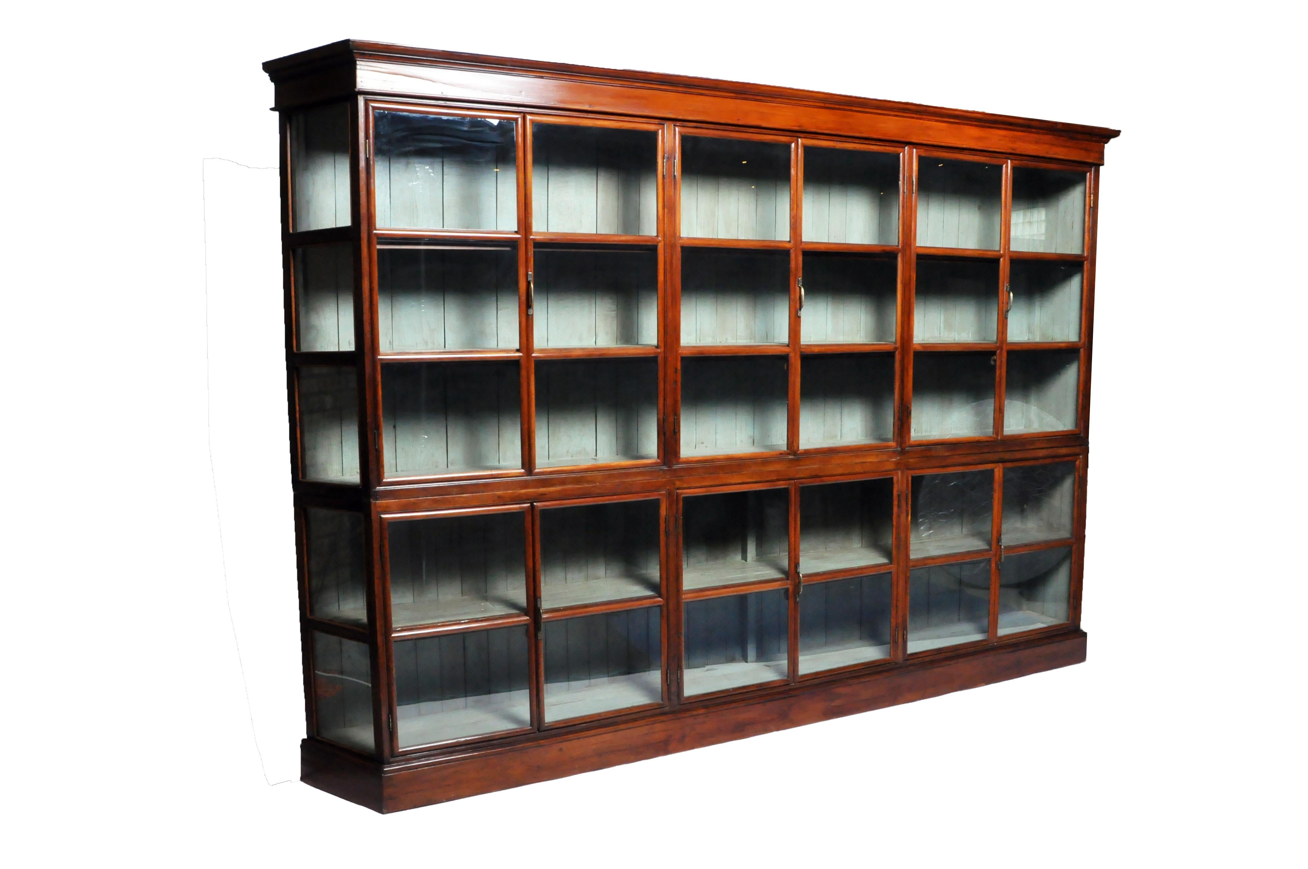 This impressive cabinet comes in two parts; the top has three sets of glass pane doors that open to shelves on top and three sets of glass pane doors on the bottom for additional storage. Its scale and ample storage make this a perfect book display
