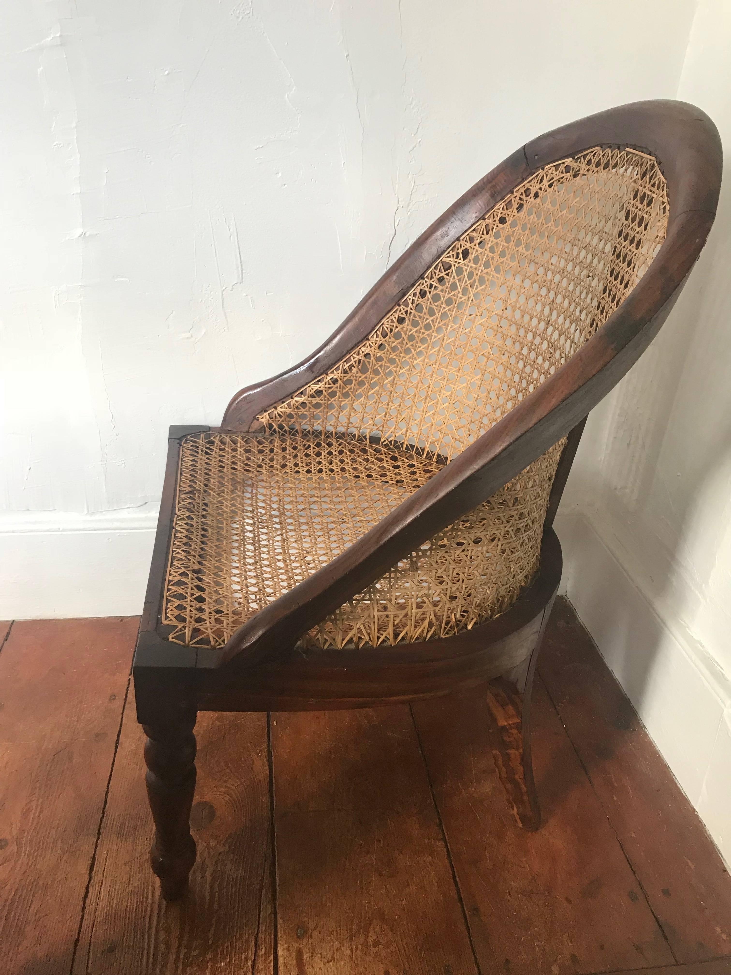 British Colonial, Ceylonese, Nadoun wood and caned nursery chair, circa 1900. Beautiful rounded back with hand-caned seat and back, sitting on turned legs.
Nadoun wood is native to Sri Lanka and has natural striations running through it. This is a
