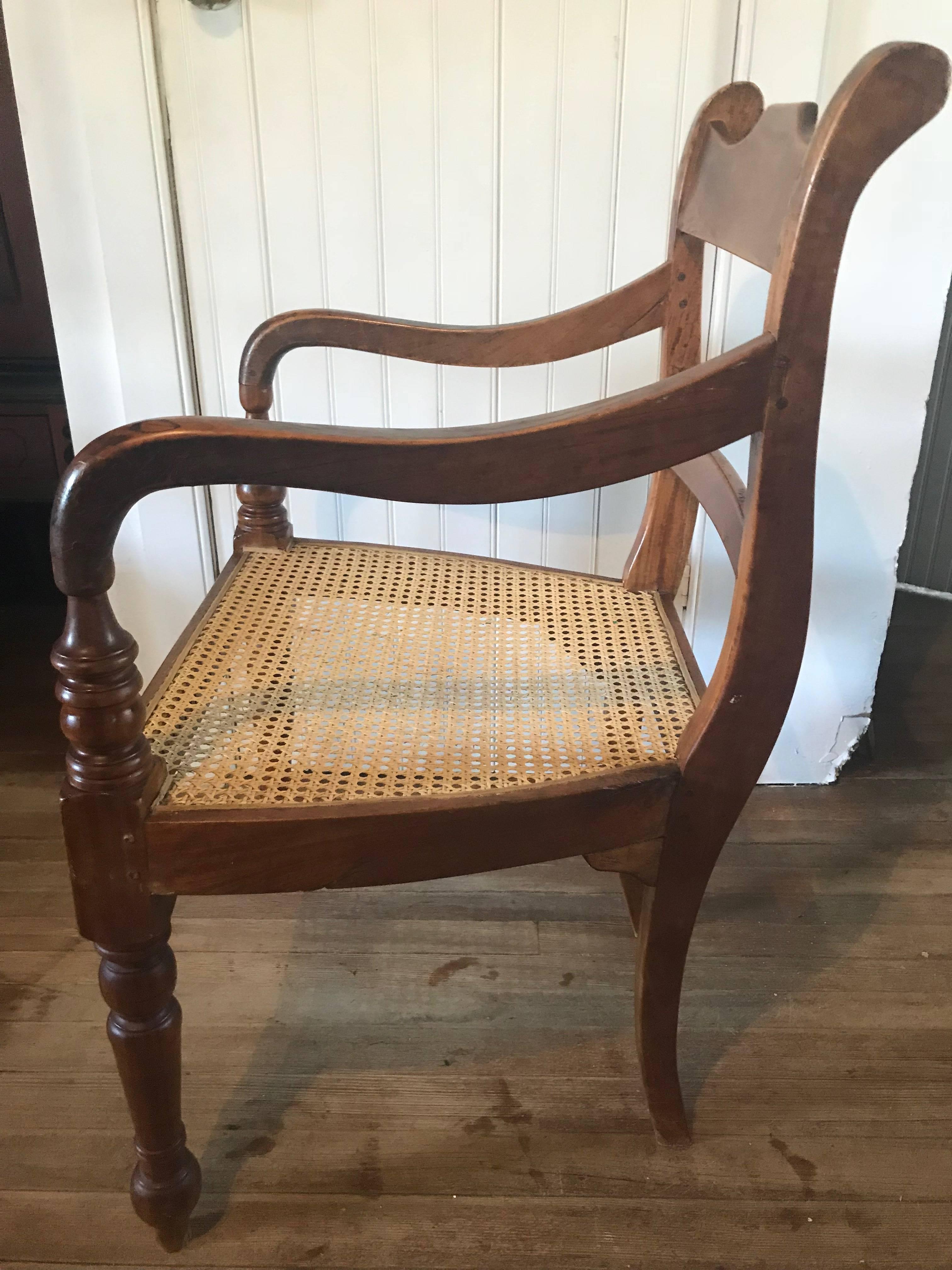 British Colonial, Ceylonese, solid satinwood caned armchair, circa 1900. Beautiful old peg construction, hand carving, and hand-caning. This piece is made from solid satinwood. It was imported in the 1980s from Sri Lanka. This was probably used as a