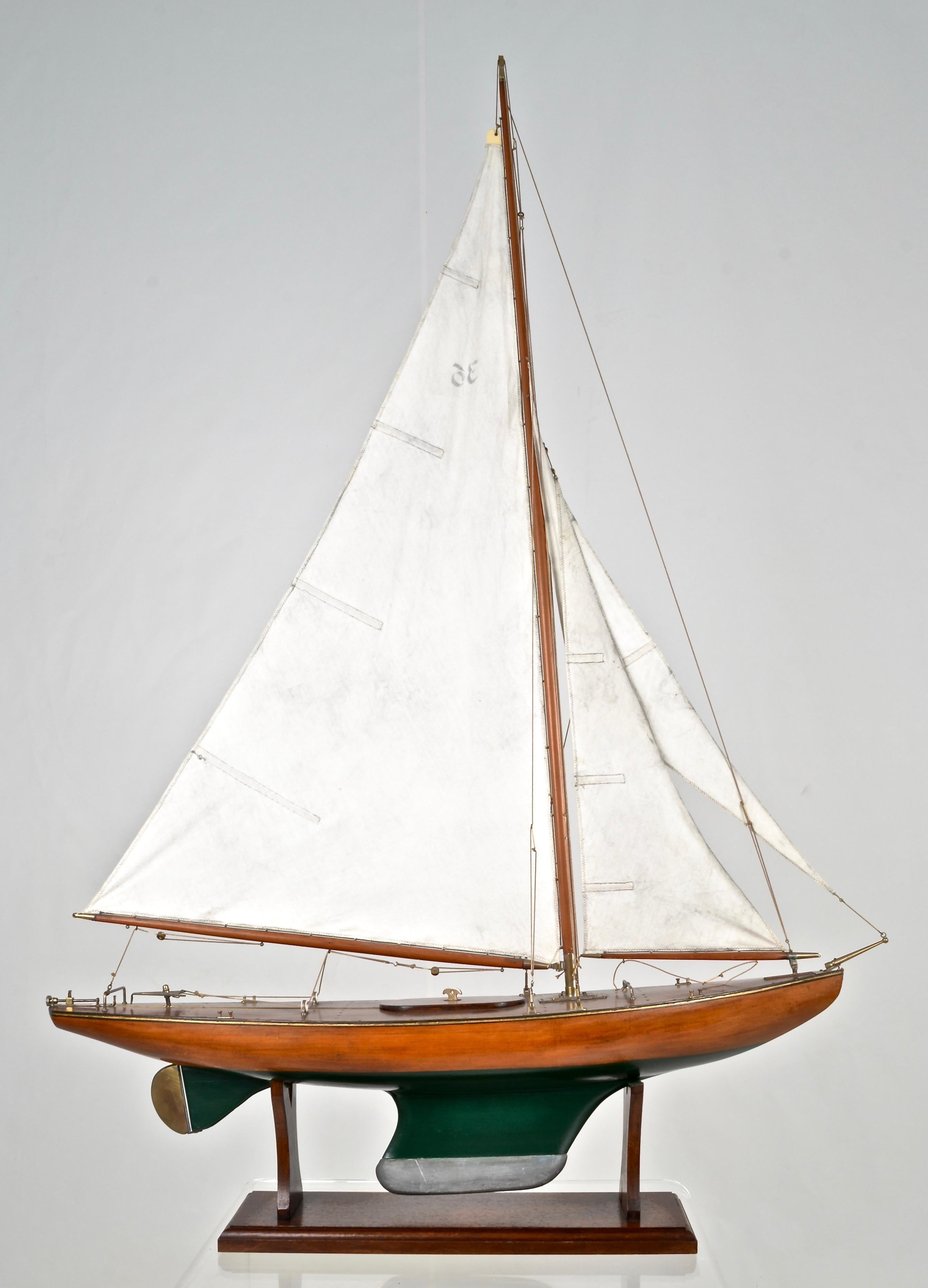 An outstanding example of a traditional pond boat featuring great details such as planked deck and unusual brass fittings. Cutter rigged. Weighted keel. Very nice size at 39 inches total length and 56 inch height. Custom stand. Very fine condition.
