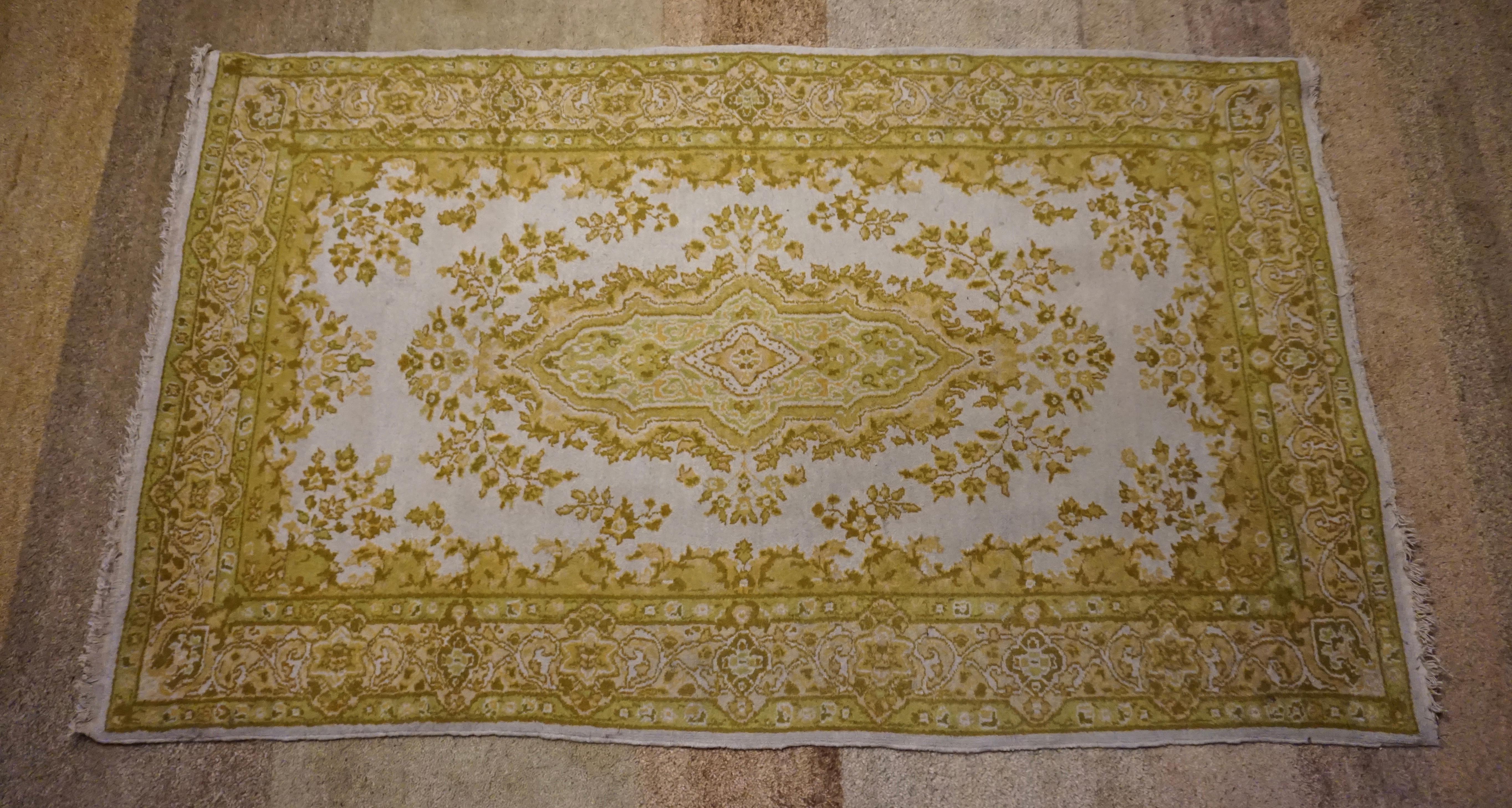 Finely knotted wool rug from Kashmir in unique hues. Has a rare mossy green tone. Medallion and floral theme with open field. Delicate work. In good condition with some wear in tassels consistent with age,

circa 1940s.