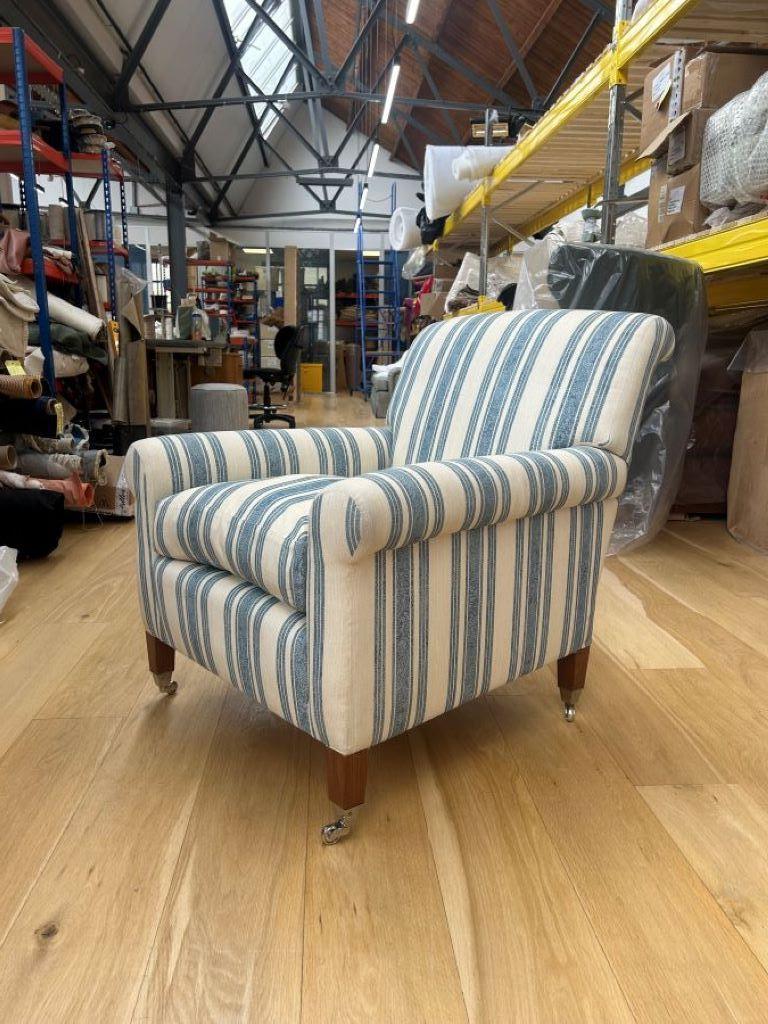 This armchair is handmade at Dudgeon's workshop in Chiswick. It has a solid, British made beech frame and is traditionally made with hand tied double cone coil springs and a bamboo cane sprung edge. The pillow is a mix of feather and down. It is a
