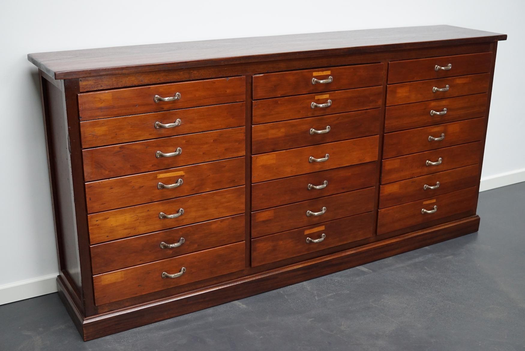 This vintage mahogany bank of drawers dates from the 1930s and was made in England. It features a mahogany frame, top and drawer fronts with metal handles. The interior dimensions of the drawers are: D x W x H 29 x 51 x 5 and 7 cm. We have two
