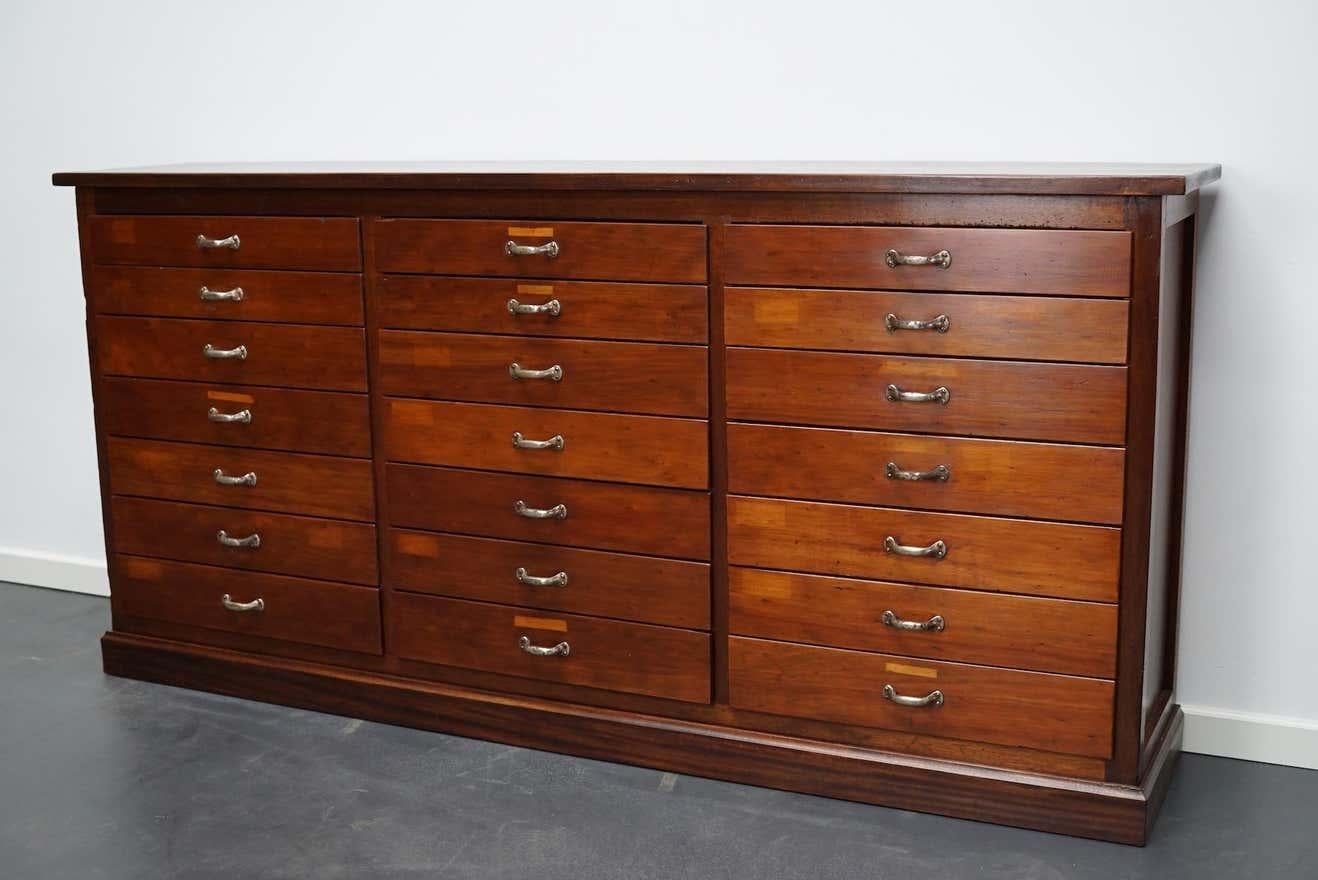 This vintage mahogany bank of drawers dates from the 1930s and was made in England. It features a mahogany frame, top and drawer fronts with metal handles. The interior dimensions of the drawers are: D x W x H 29 x 51 x 5 and 7 cm.