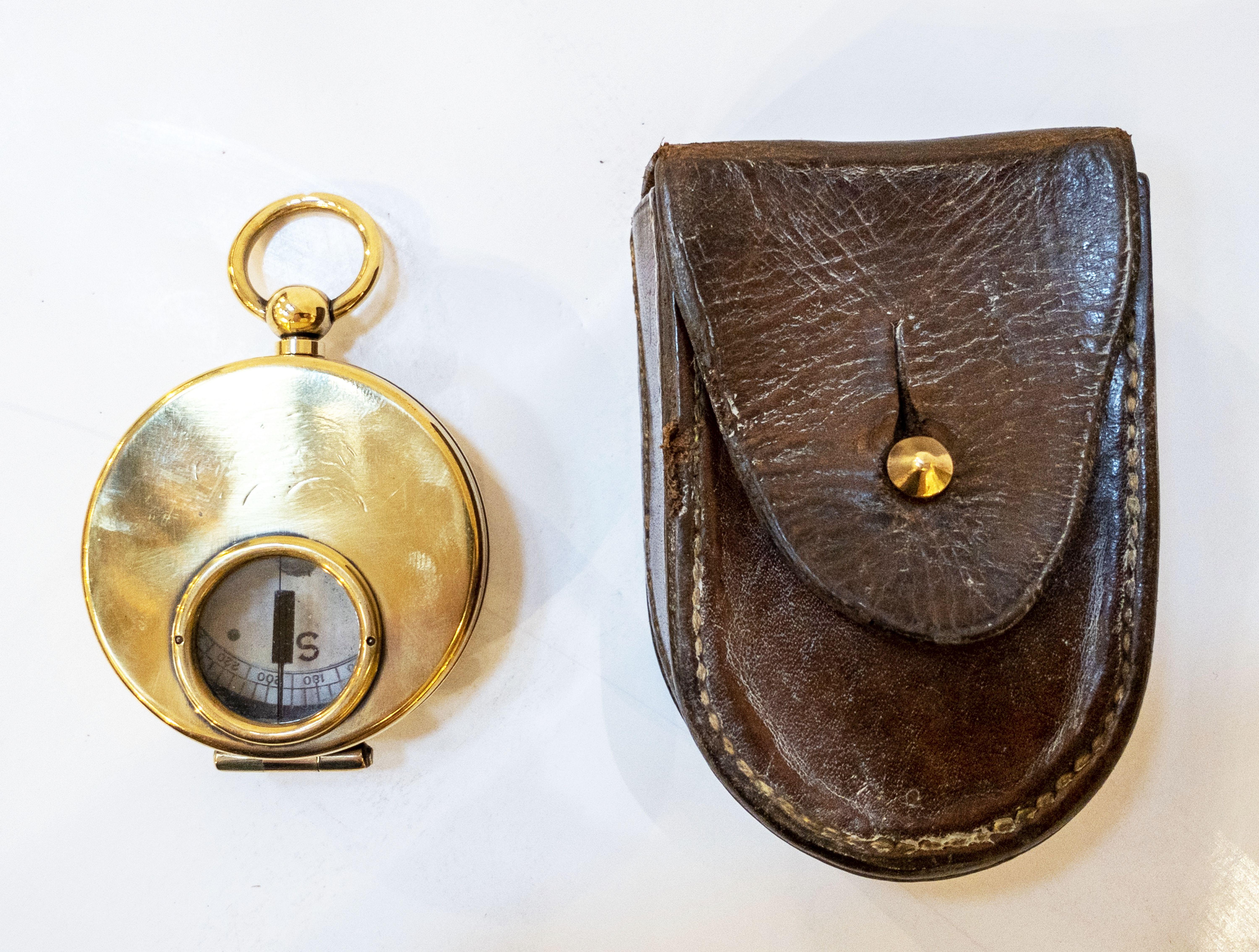 A working British military officer's marching or sighting compass of heavy brass in original leather case.