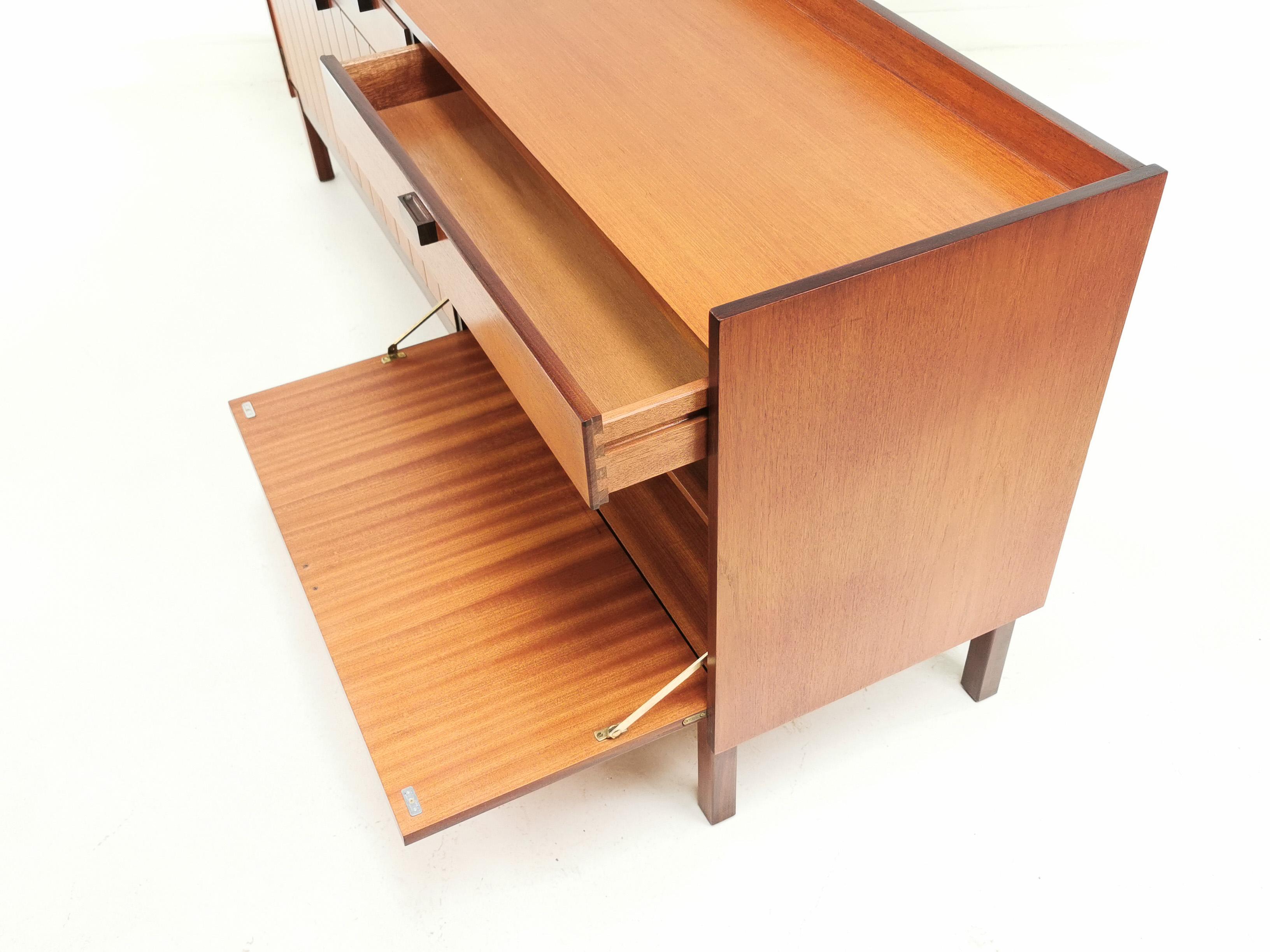 Meredew teak sideboard 

British made, Danish design mid century 1960s eye catching teaksideboard by Meredew.

A rectangular top above two spacious drawers, two cupboard doors to the left and drinks cabinet to the right.

Very unique design,