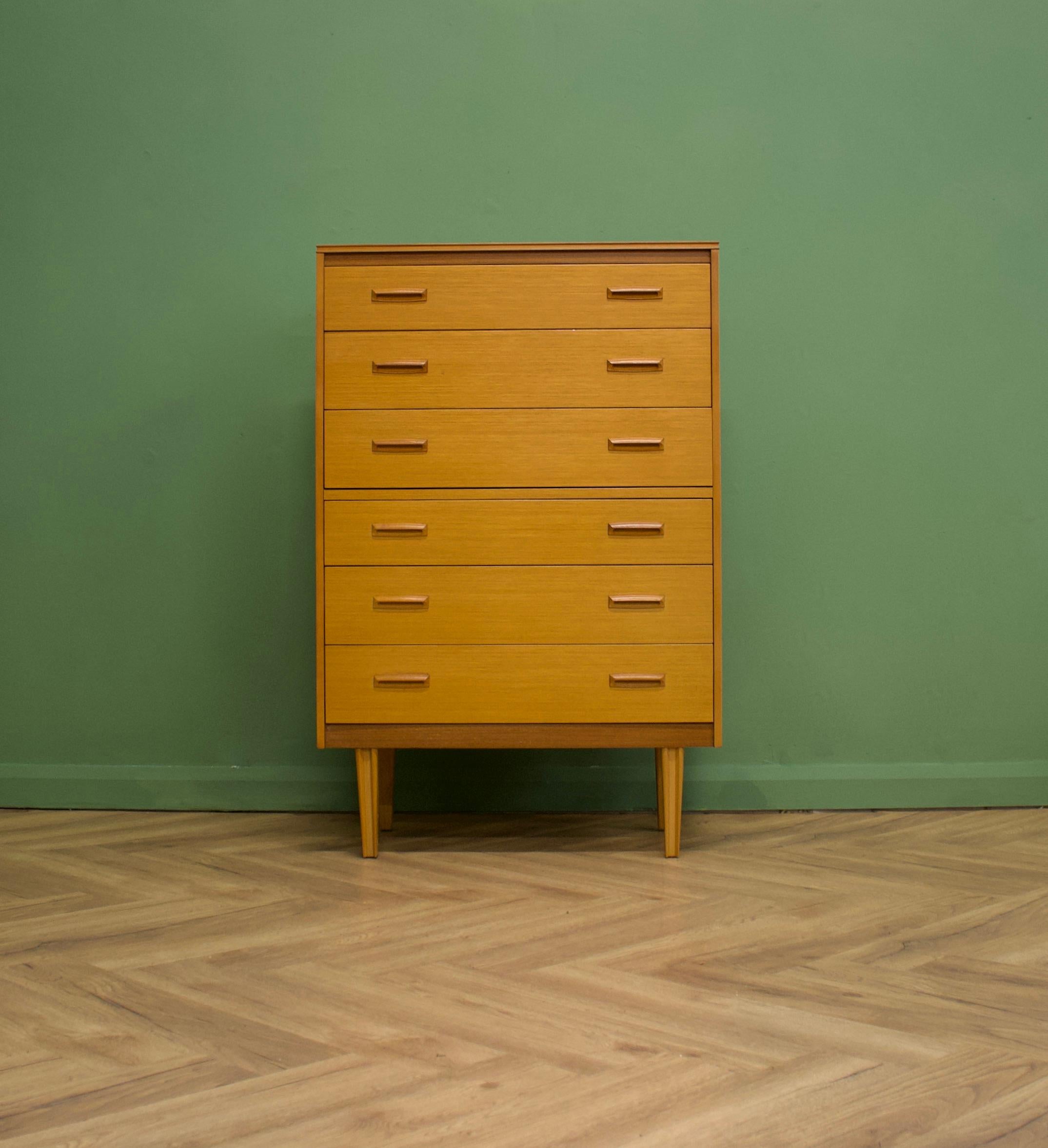 A midcentury oak tallboy chest of drawers from Lebus
With six drawers for ample storage
Featuring wooden square cup handles - which are very Scandinavian in style
This piece stands on tapered legs.