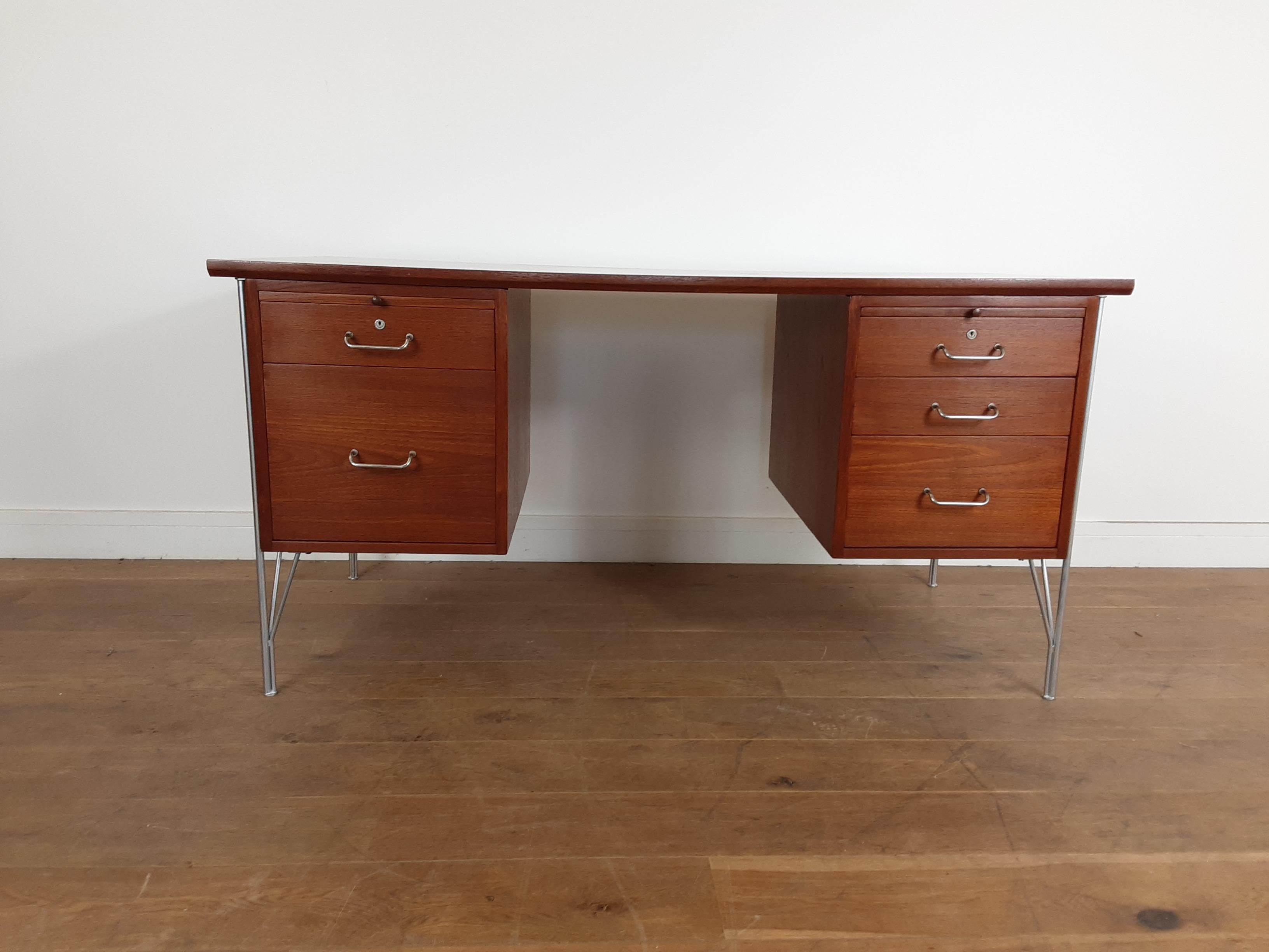 Rare Mid-Century Modern design golden teak wood desk raised on tubular polished metal supports, giving a very smart style.
Two pull out / pull-out writing slopes, bank of three drawers to the right a filing drawer and single drawer to the