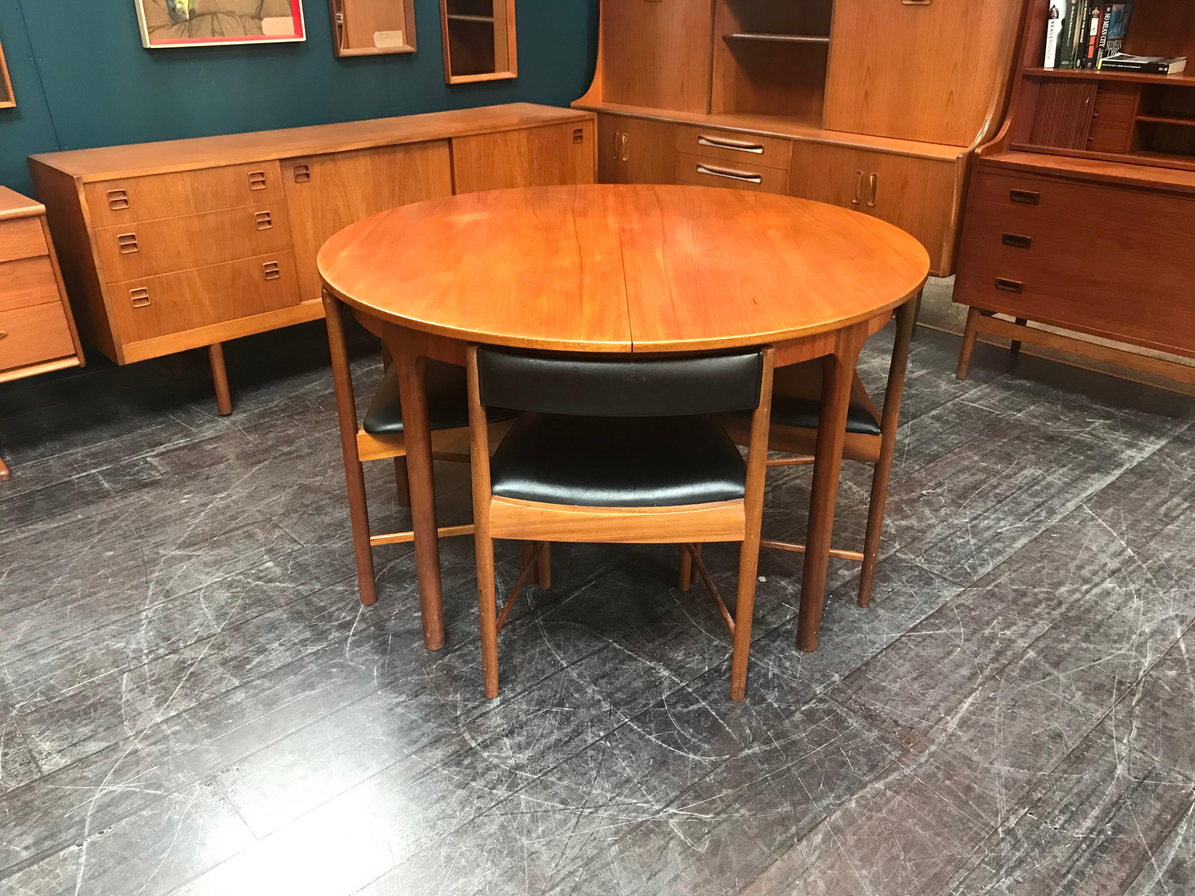 This classic mid-century dining table comes with 4 chairs and extends to accommodate 6 people, if required. The chairs and table are cleverly designed so that the chairs all neatly tuck under the edge of the table top. Space saving and… very cool to