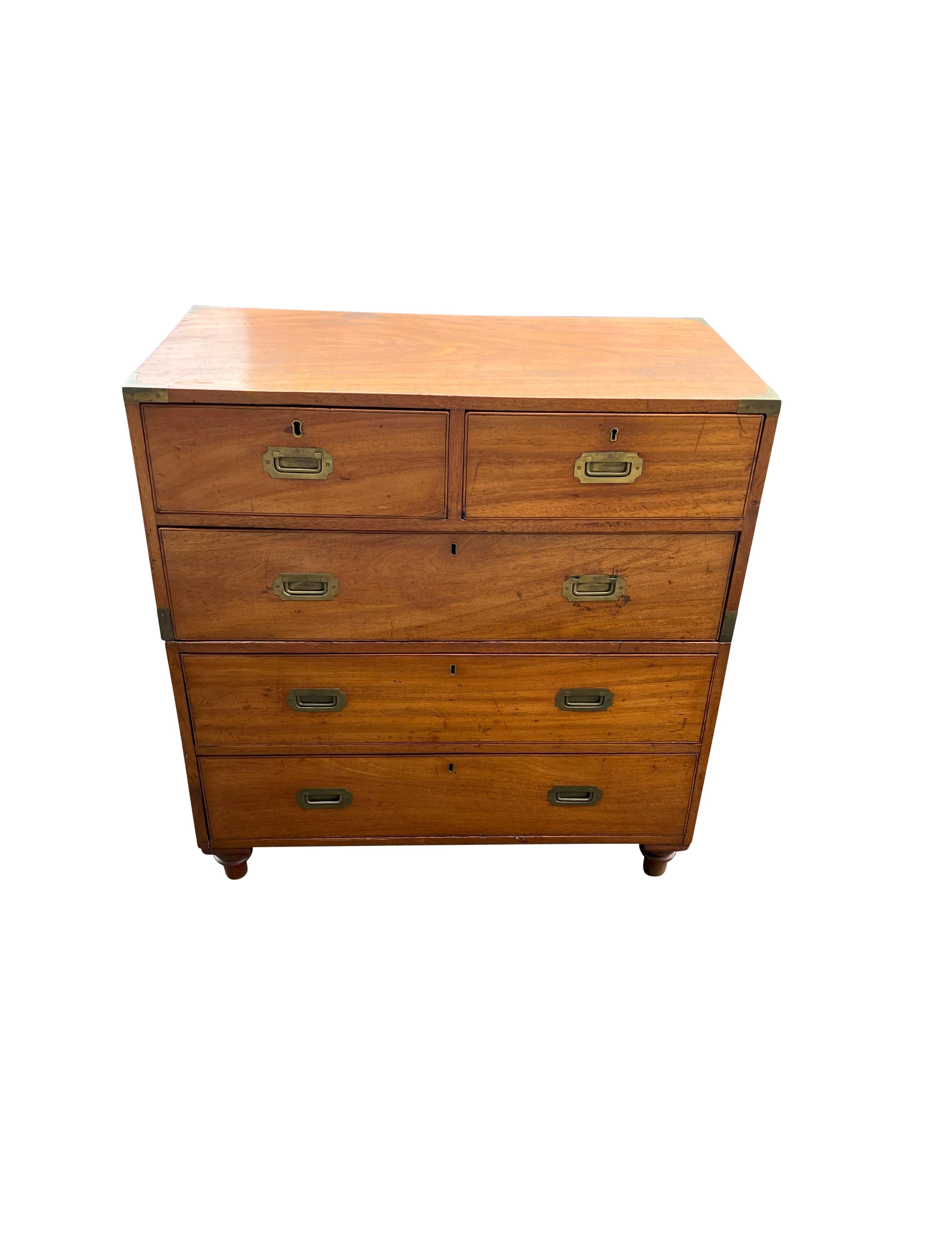 Typical form in two sections. The top with brass corners and two over one long drawer. The lower case with two drawers. Toupie feet. Recessed flush brass handles.