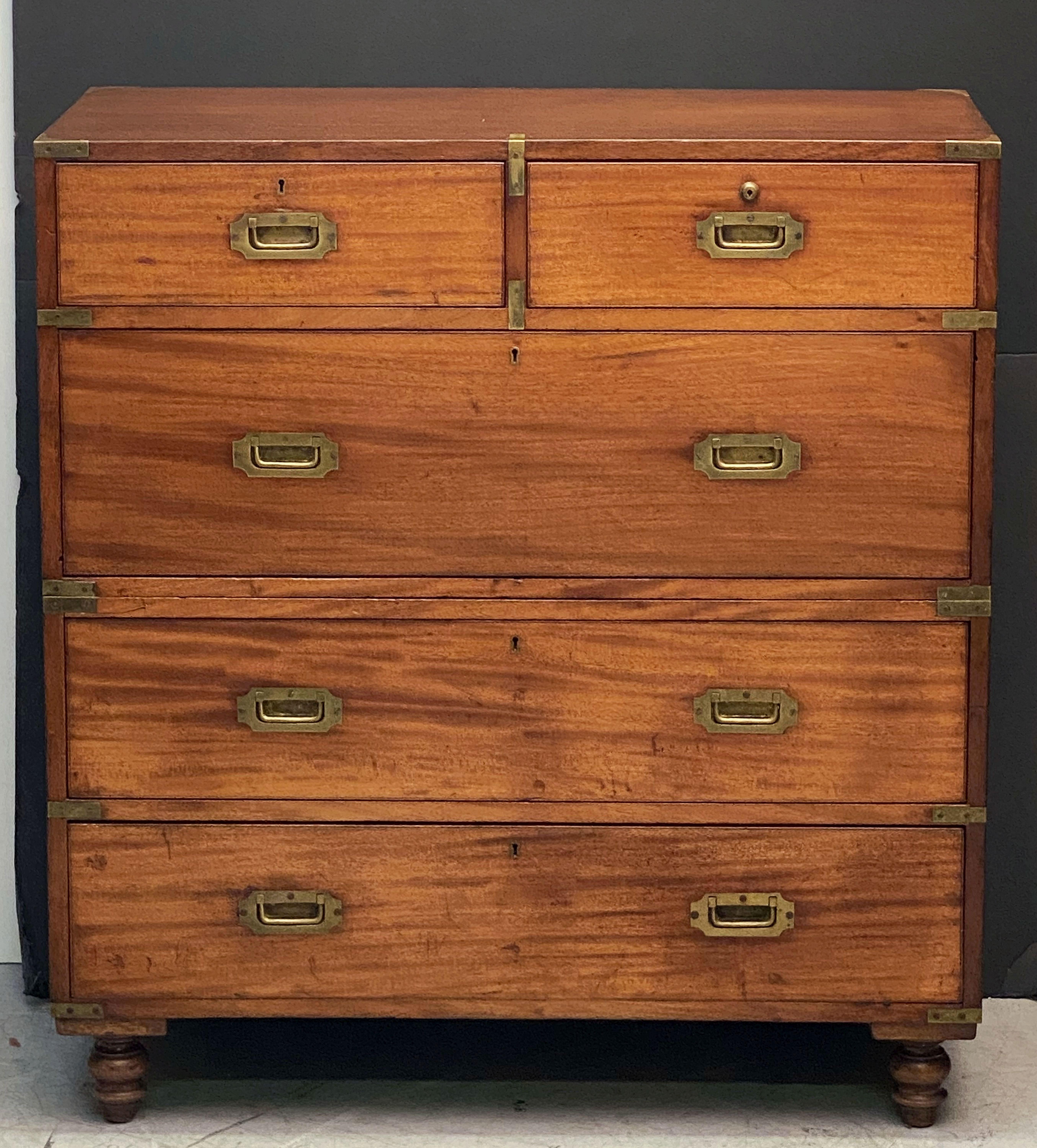 A fine English military officer’s Campaign Ware chest, featuring a handsome mahogany exterior, showing two short drawers over three long drawers.
The brass-bound chest, in two parts, accented with brass escutcheons and hardware, resting on four