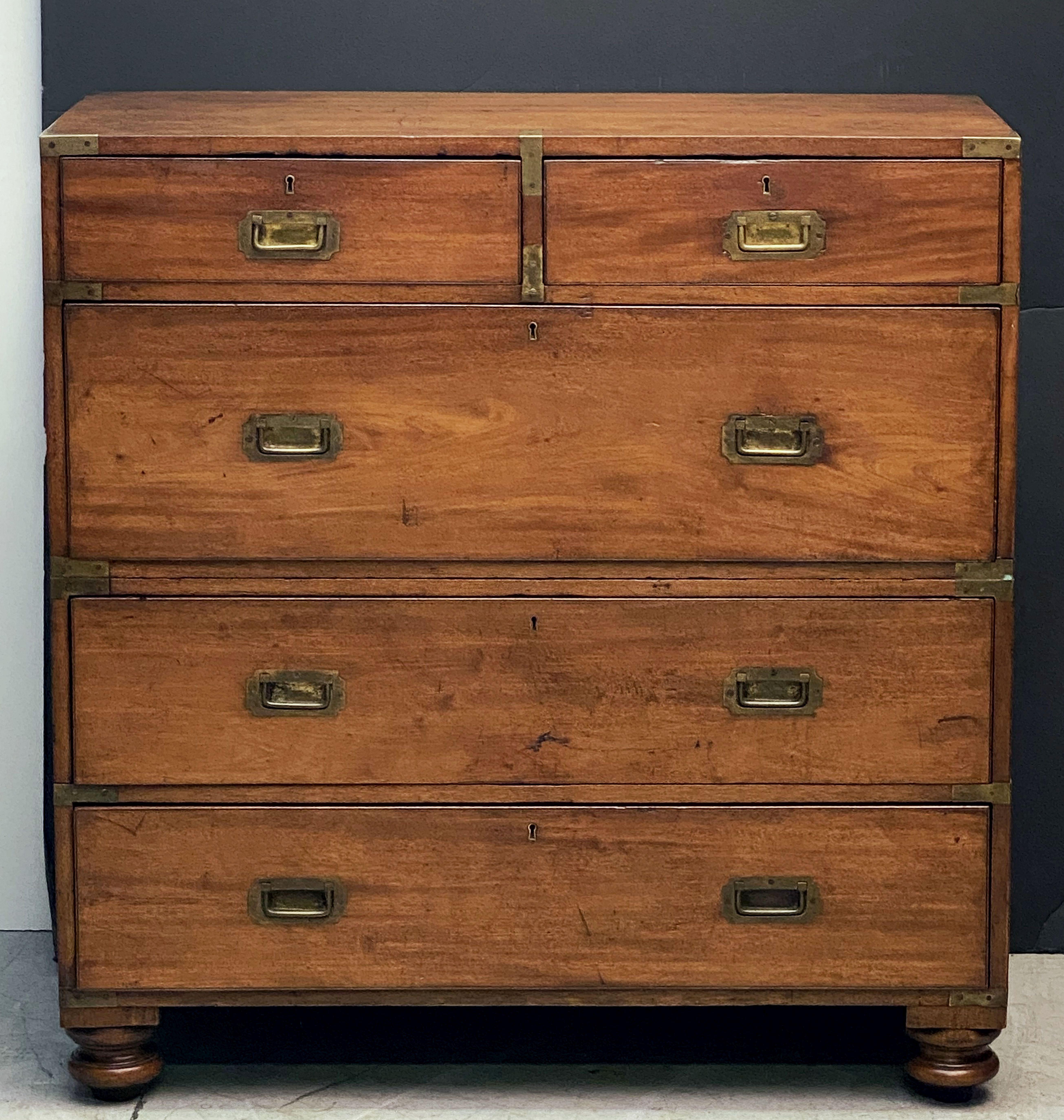 A fine English military officer’s campaign ware chest, featuring a handsome mahogany exterior, showing two short drawers over three long drawers.
The brass-bound chest, in two parts, accented with brass escutcheons and hardware, resting on four