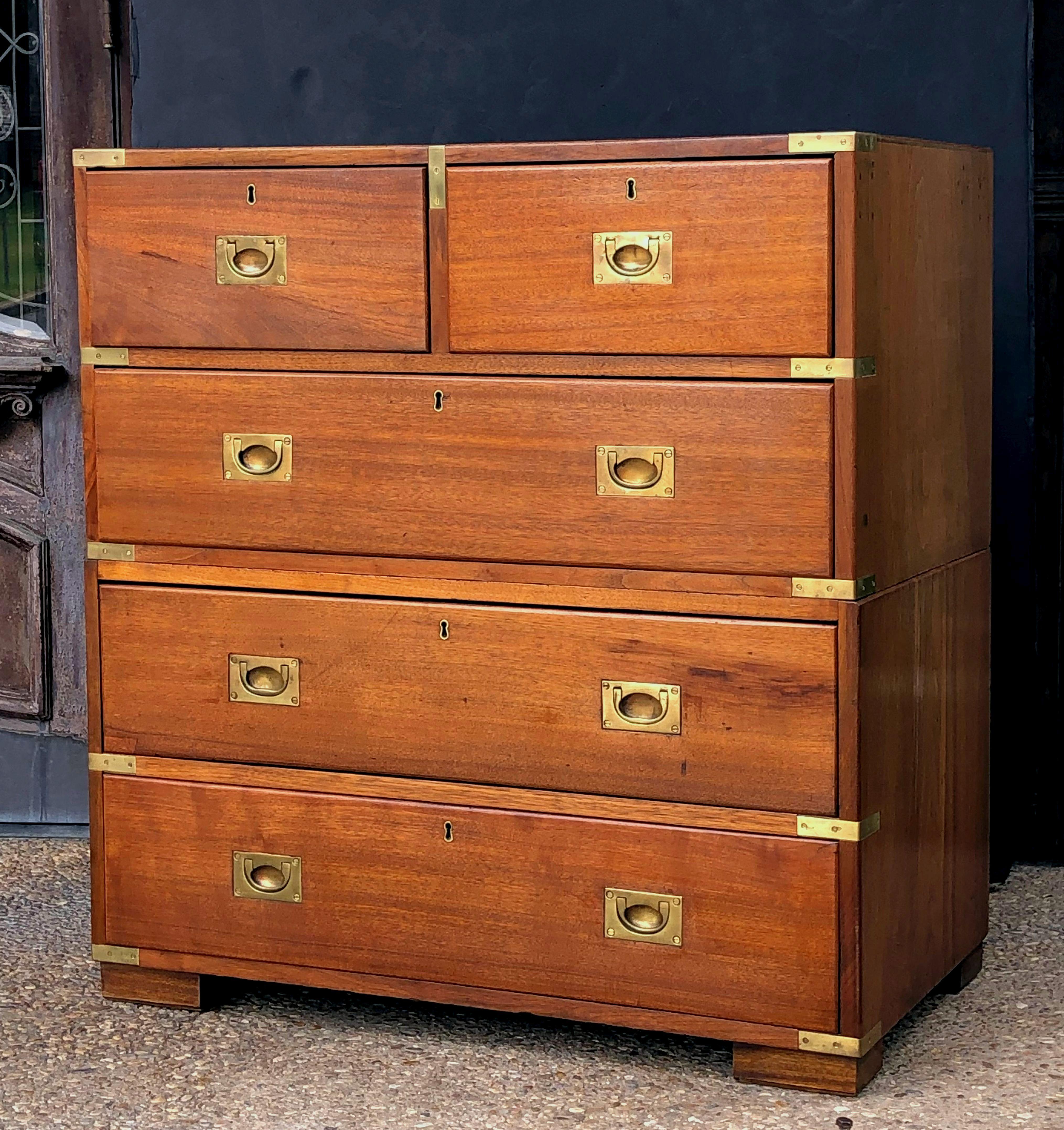 A fine English military officer’s Campaign Ware chest, from the 19th c., featuring a handsome oak and mahogany exterior, showing two short drawers over three long drawers. The brass-bound chest, in two parts, accented with brass hardware, resting on