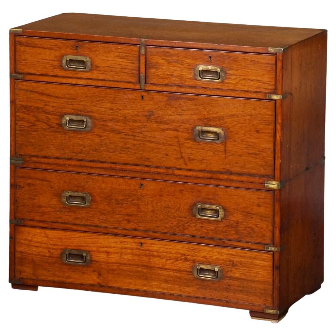 A fine English military officer’s Campaign Ware chest, from the 19th century, featuring a handsome teak exterior, showing two short drawers over three long drawers. The brass-bound chest, in two parts, accented with brass hardware, resting on four