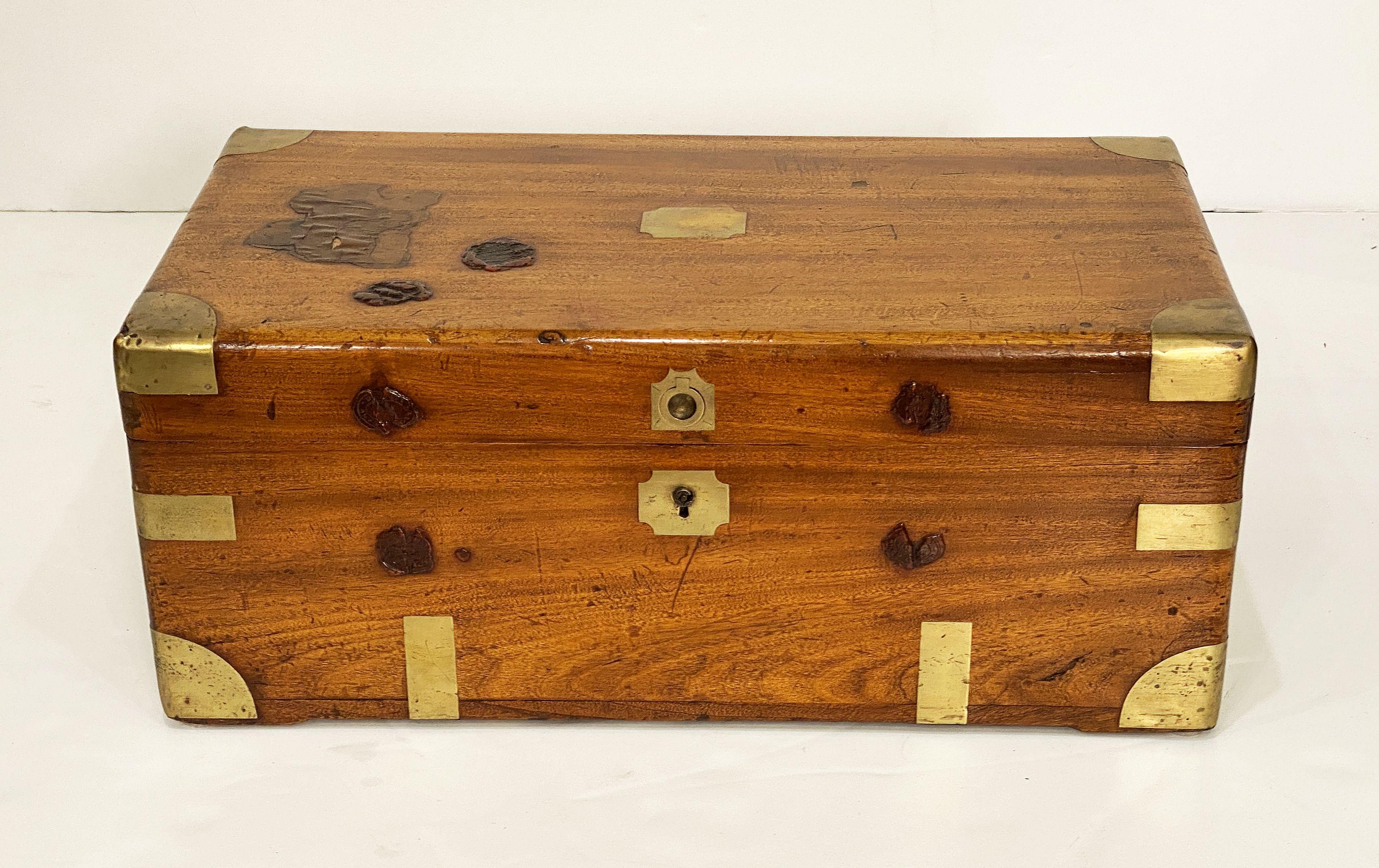 A handsome rectangular British military officer's Campaign trunk of camphorwood featuring hand-cut brass binding and hardware, with opposing handles, and wax seals or stamps from ports-of-call on the top and front.

Campaign-era trunks and coffers