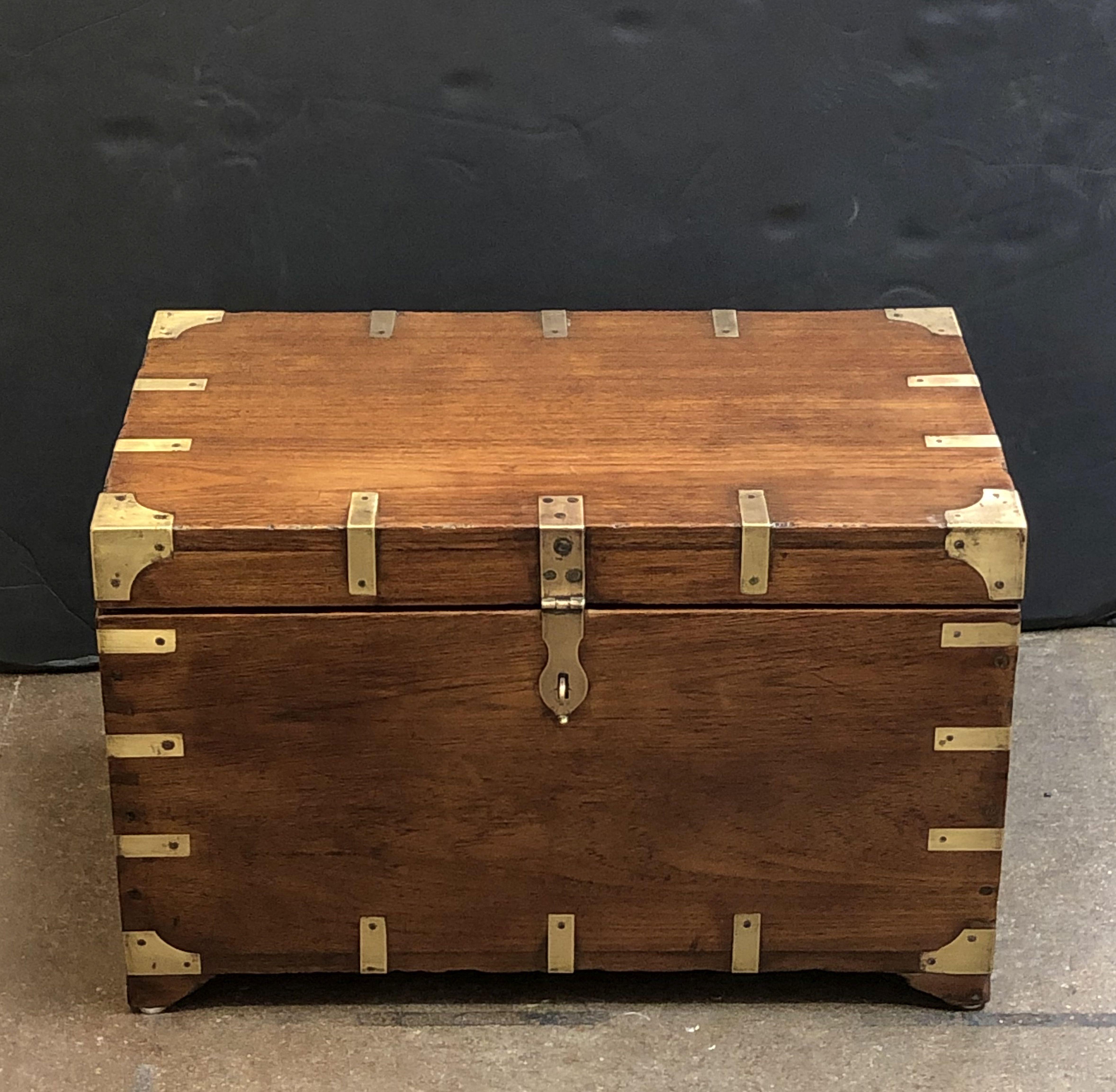 A handsome rectangular British military officer's Campaign trunk of teak featuring hand-cut brass binding and hardware, with interior compartments, and resting on bracket feet.

Campaign-era trunks and coffers were the travel items of British