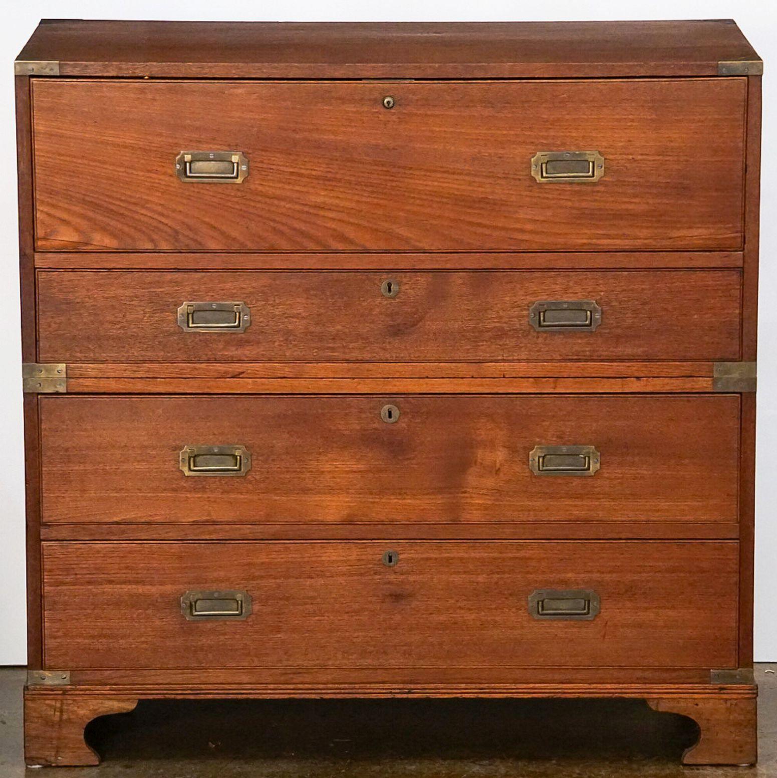 A fine British military officer’s Campaign ware secretary or secretaire, fashioned as a chest of drawers, featuring a teak exterior, showing four long drawers. The top drawer opening to a secretary desk with small drawers and compartments and a