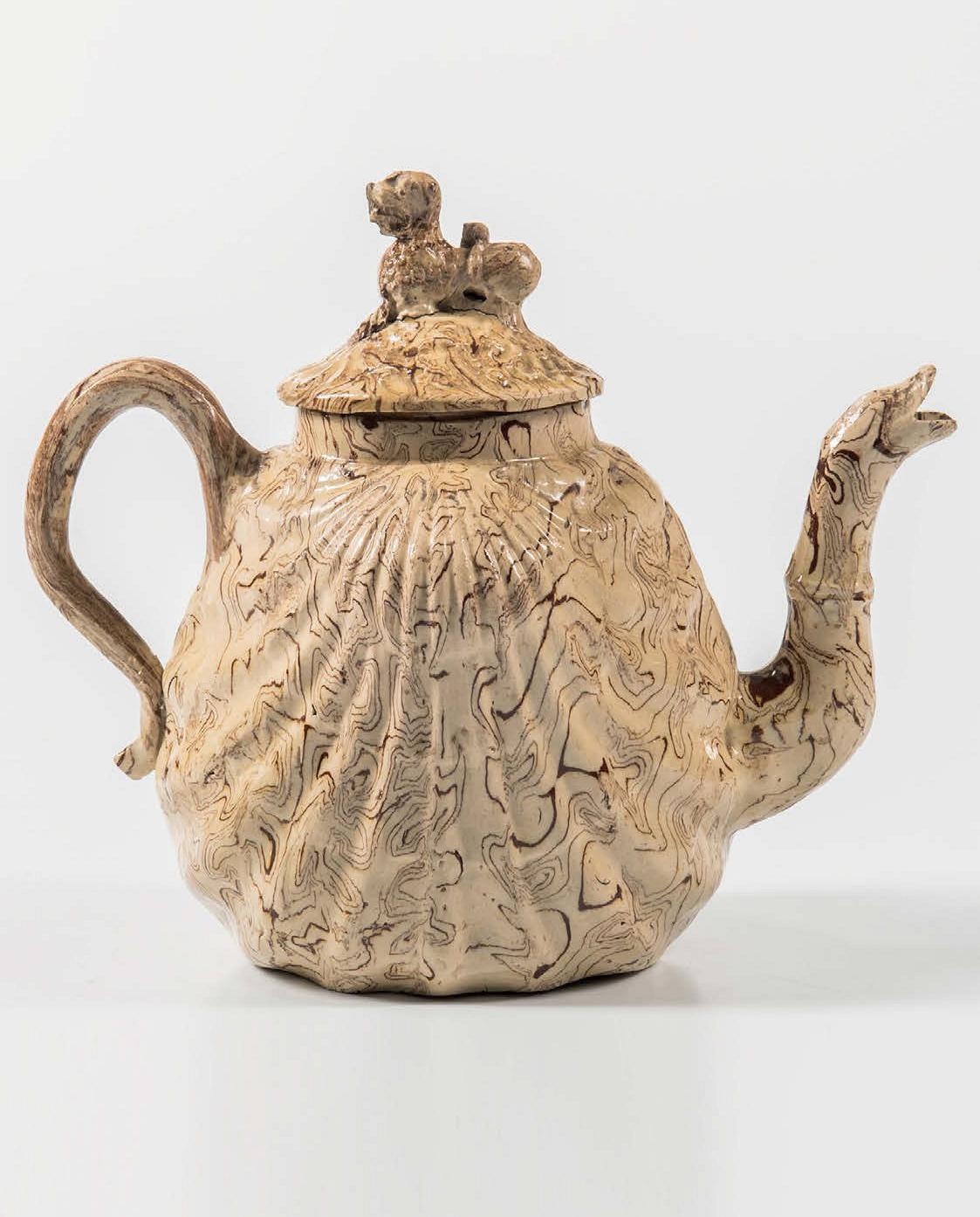 British Pottery solid agate Pecten shell teapot and cover,
circa 1755-1760.

The lead-glazed light cream and red agateware pottery teapot is molded in the form of a pecten shell with a foo-dog finial and a serpent spout.

Dimensions: 5 3/4