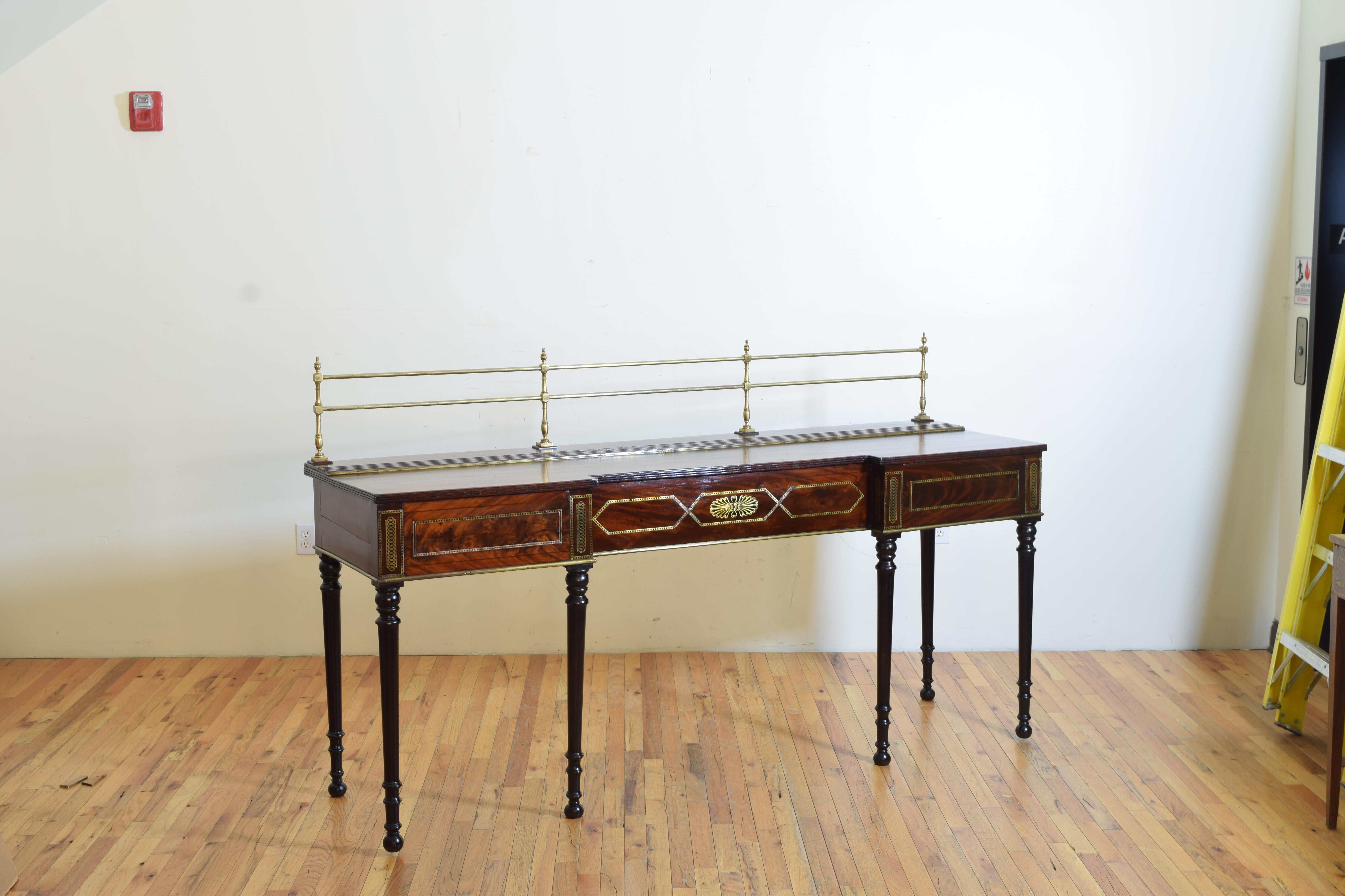 British or possibly Irish, first quarter of the 19th century, Regency period mahogany server or sideboard having a brass gallery rail, recessed center and geometric brass inlay, rising on turned ebonized legs.

Height of server itself is 36.25
