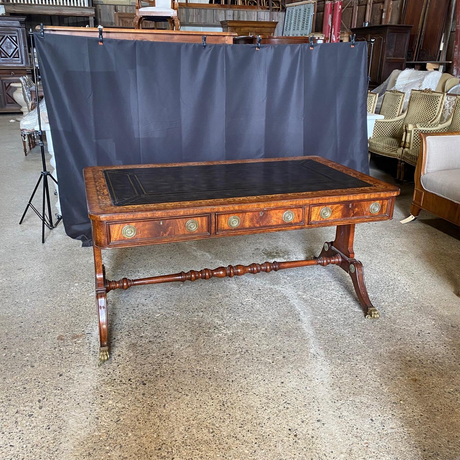 Stunning late 20th Century Regency style two-sided faux partners desk comprised of a mahogany frame, embossed Florentine leather inset top, and brass details by Maitland-Smith.  The wonderful curule or trestle base and spectacular splayed legs are