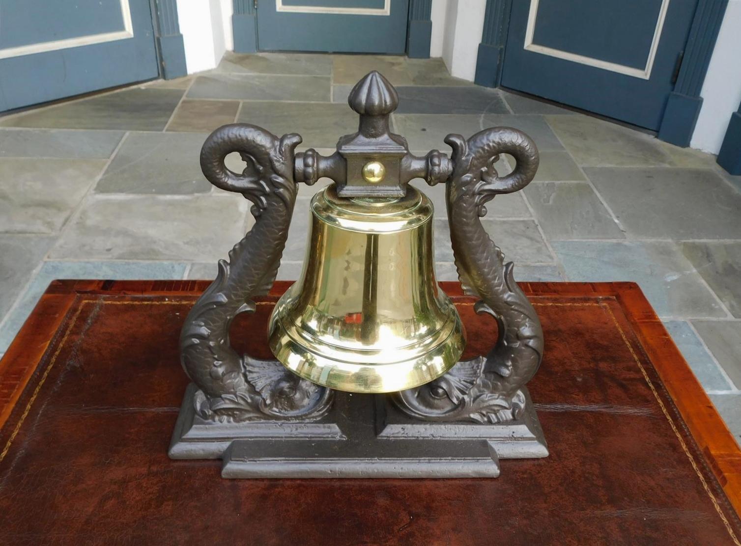 British Royal Navy Admiral solid brass ship bell mounted on flanking intertwined dolphin cast iron yoke. Mid 19th Century.