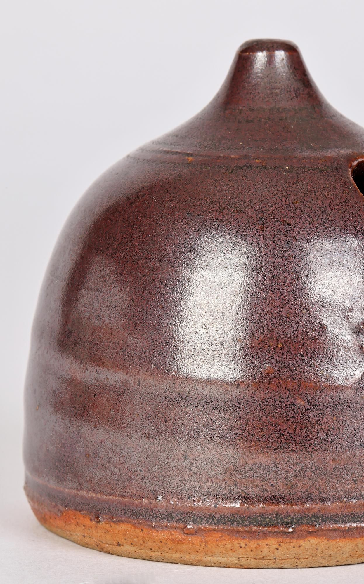 An unusual and finely hand crafted studio pottery water dropper or inkwell decorated in brown glazes dating from the 20th century. The hand thrown hive shaped vessel stands on a flat round unglazed base with a combed finish with a rounded body