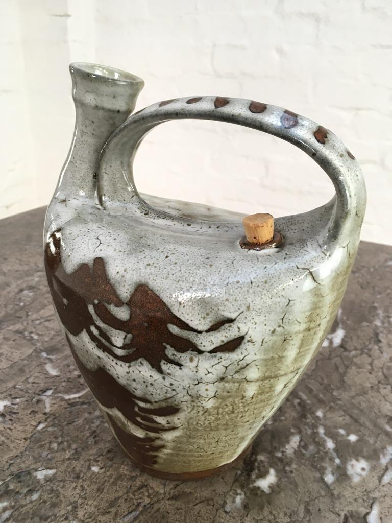 An earthenware carafe by Joe Finch, respected British studio potter. Joe is the son of Ray Finch of Winchcombe Pottery, where he began his career in 1964. 

Finch has a strong preference for wood firing. He has been based in West Wales since the