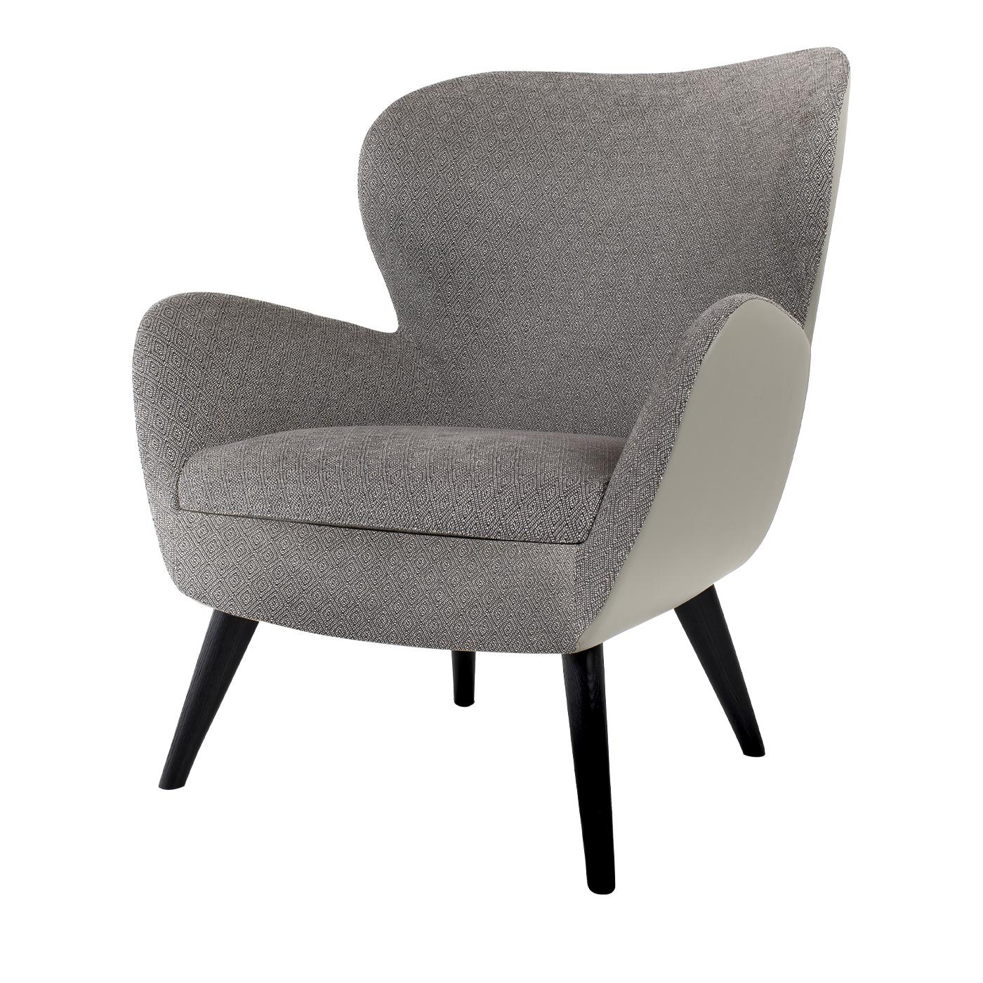This retro style armchair with a 1960s inspired design elegantly combines an external leather layer and an internal fabric one, both in a stylish nuance of pewter. Well-padded, comfortable and enveloping, this chair will make a statement in your