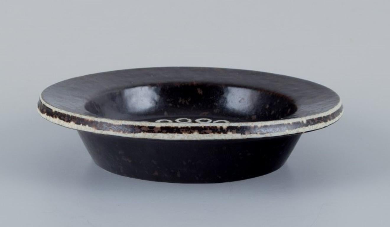 Britt-Louise Sundell (1928-2011) for Gustavsberg Studio, Sweden.
Ceramic bowl in dark brown and sand-colored glaze.
Approx. 1960.
Marked.
In excellent condition.
First factory quality.
Dimensions: H 3.5 cm x D 15.5 cm.

