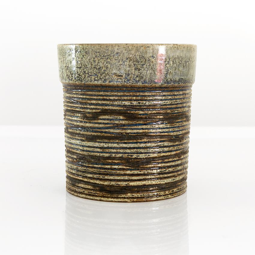 Eine zylinderförmige Vase von Britt-Louise Sundell für Gustavsberg, um 1960. Die Vase hat eine stark strukturierte Oberfläche mit horizontalen Linien aus Schamotte-Ton.

Maße: Höhe: 6,5