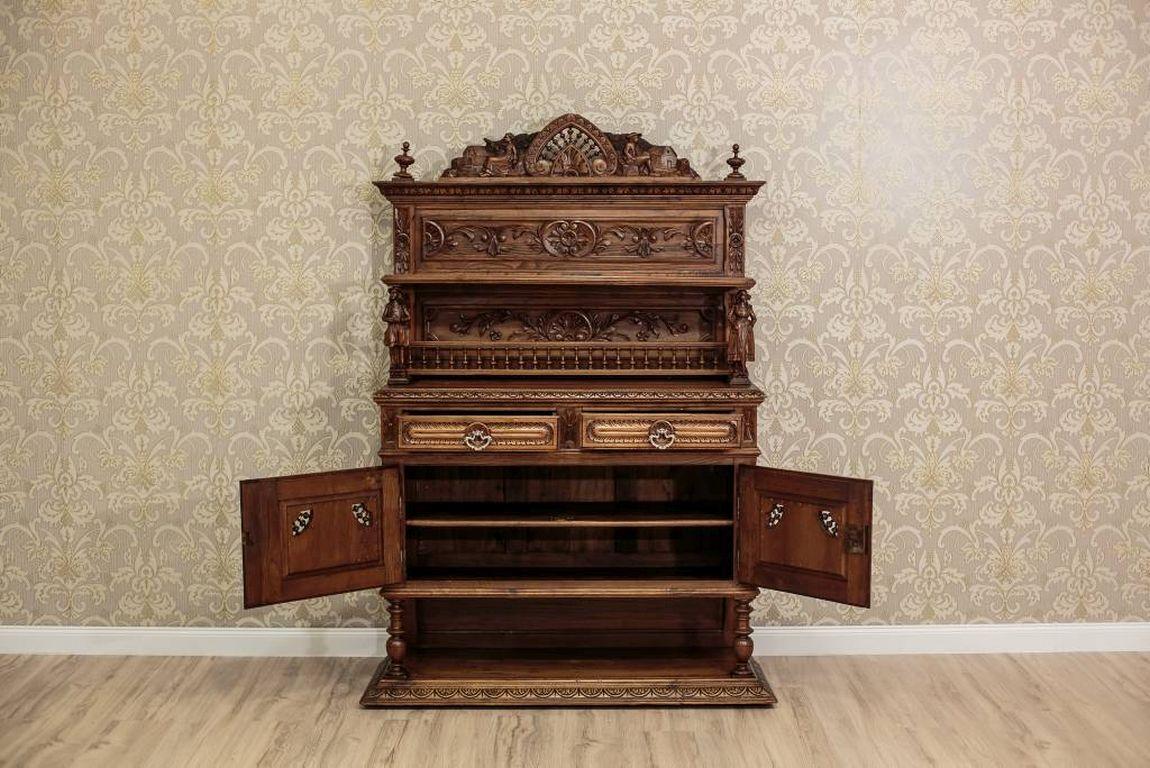 A sideboard in the Brittany style, made in oakwood. This piece of furniture is composed of two segments: a bottom, and an upper part. The bottom is in the chest form, supported on balusters, which are situated on a cornice that ends with a molding.