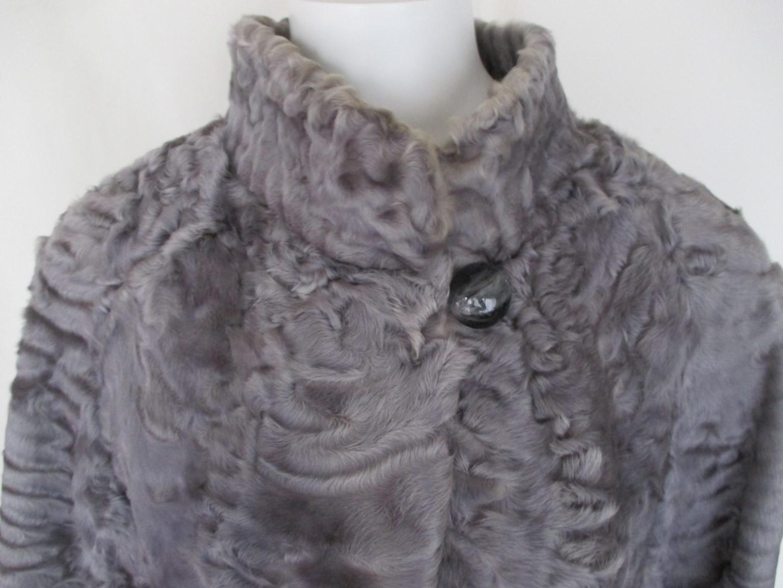 This coat has 2 pockets, 1 button at the collar, 3 closing hooks.
Broadtail fur is is the highest valued type of lamb fur.
Color: silver-grey-blue
This fur is soft and has little wear at the lining.
The size is about medium.
Please note that vintage