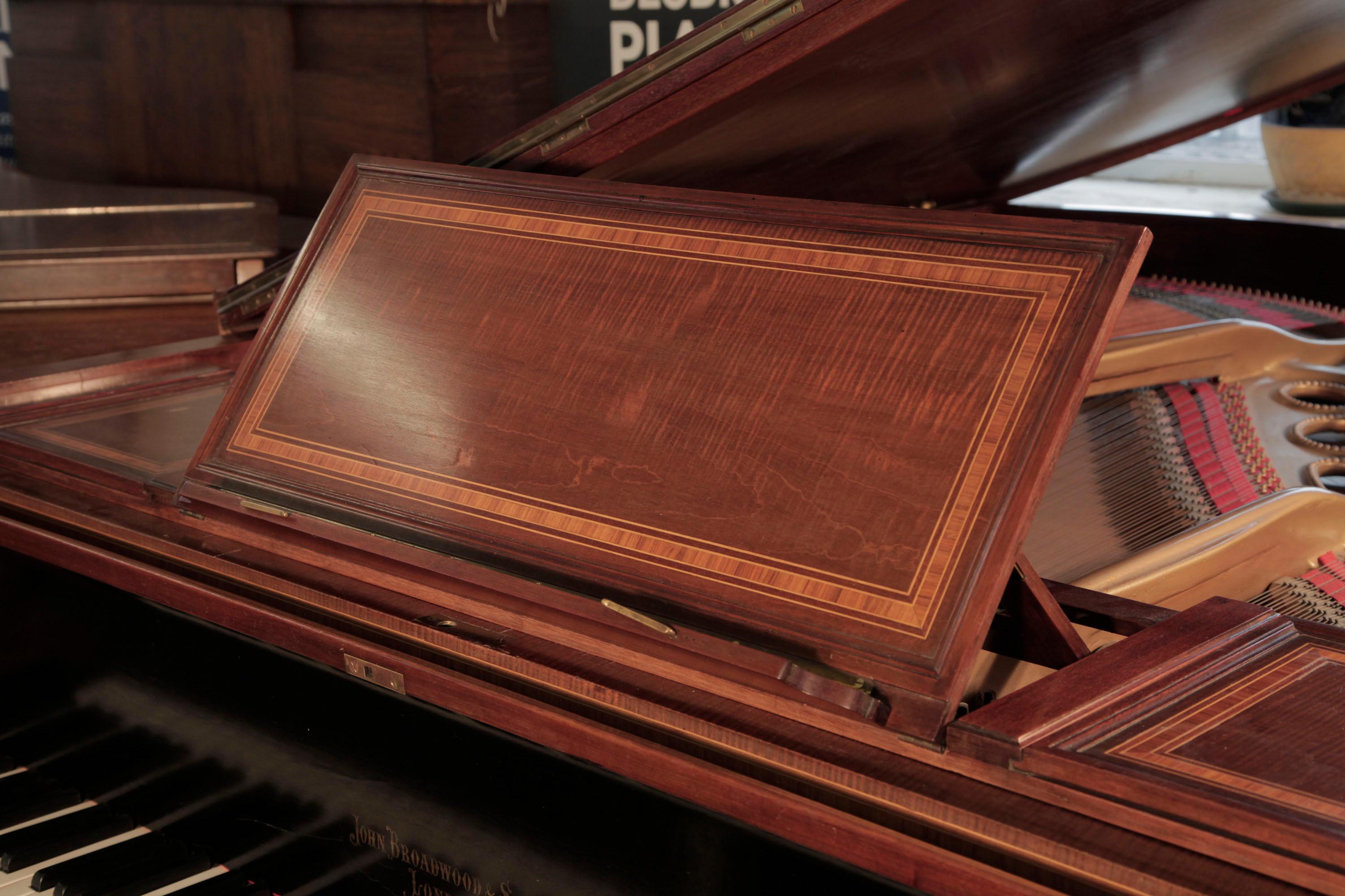 An 1894, Broadwood grand piano with a polished, mahogany case. 
Piano has tapered, fluted gate legs with ionic capitals attached with a cross stretcher that incorporates the piano lyre. The leg architrave features carved circular strapwork, a motif