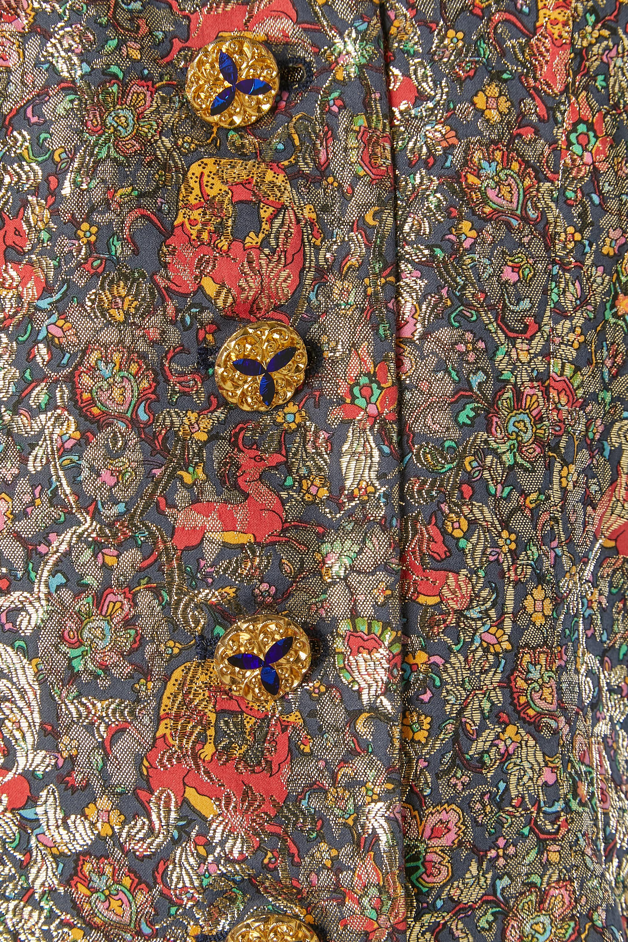 Veste de soirée en brocart et lurex à simple boutonnage avec boutons bijoux. L'étiquette de composition du tissu a été coupée mais la doublure est en satin. 
Pad d'épaule. Fente sur le devant, longueur= 6cm
Collectional 1991
TAILLE 38 (Fr) M 