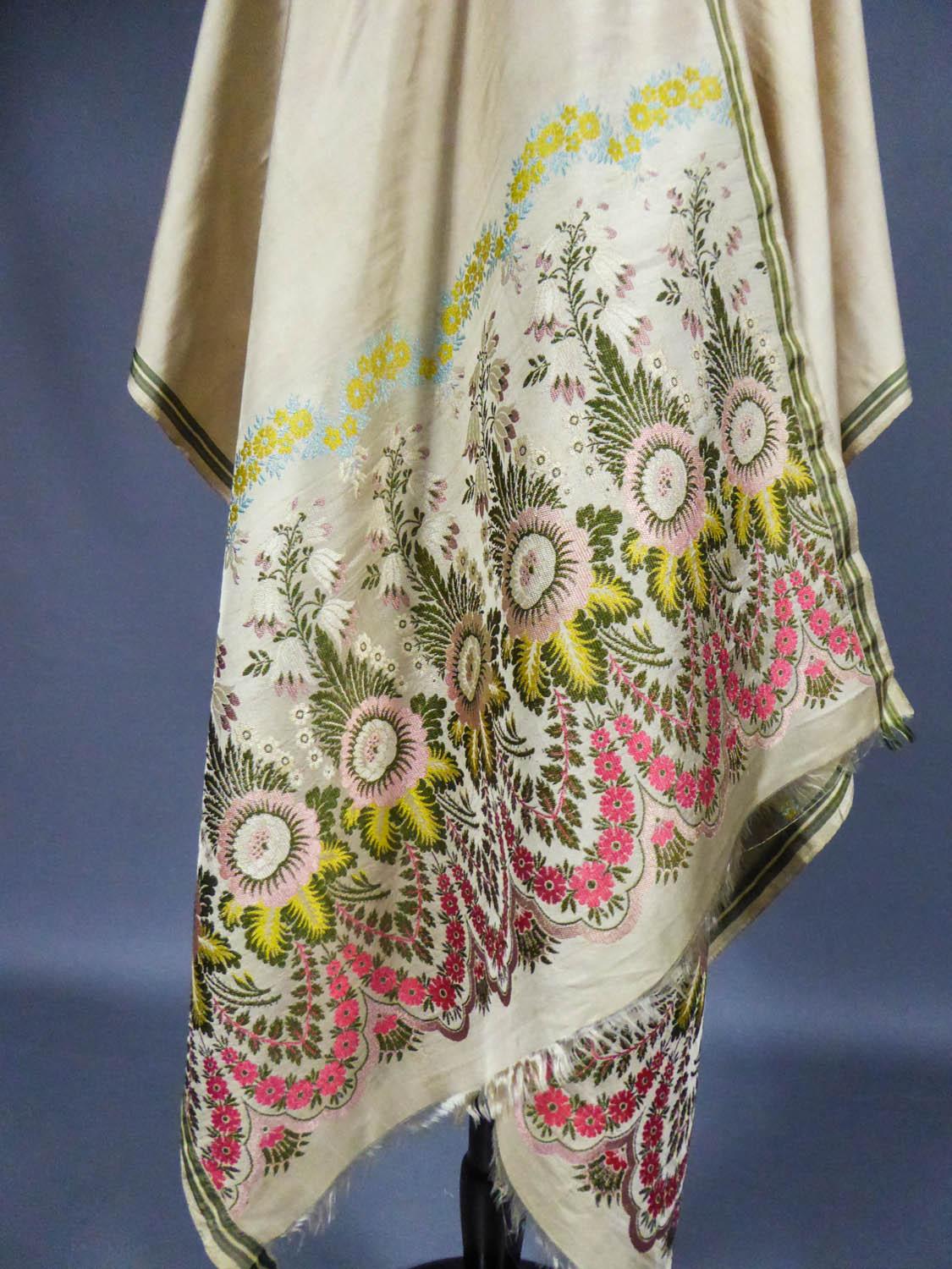 Circa 1820-1840
England

Elegant fashion scarf in brocaded silk - England, manufactory of Spitalfield around 1820. Seven boteh in bouquets of naturalistic flowers constitute each end of this scarf with ivory silk serge background. On the sides