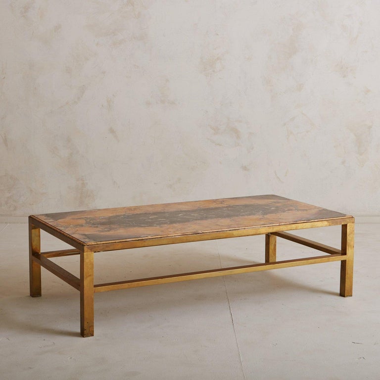A rectangular coffee table with a patinated brass base and stretcher details. This table features a stunning book-matched Brocatello marble tabletop with captivating coral and plum veining. Sourced in Italy, 20th Century.

