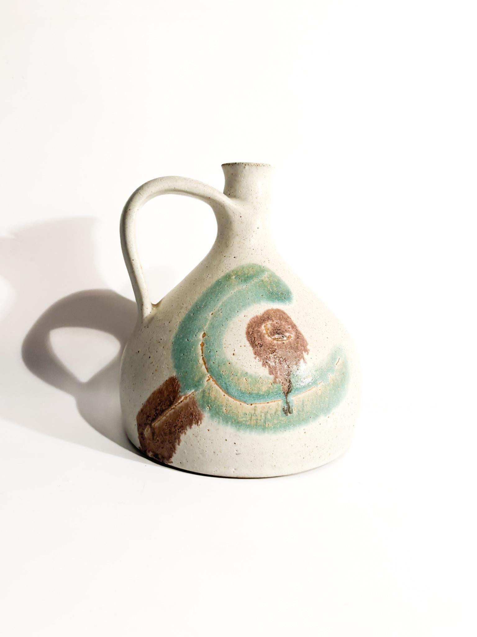 Brocca in ceramica dipinta a mano, realizzata da Bruno Gambone negli anni '70

Ø cm 20 h cm 17

Bruno Gambone (1936-2021) è stato un influente ceramista e artista italiano, ampiamente riconosciuto per il suo significativo contributo alla ceramica